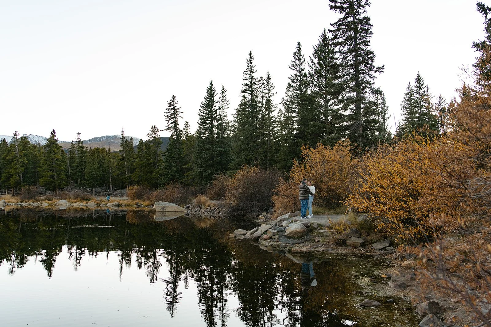 a couple hugging beside echo lake for their engagement photos