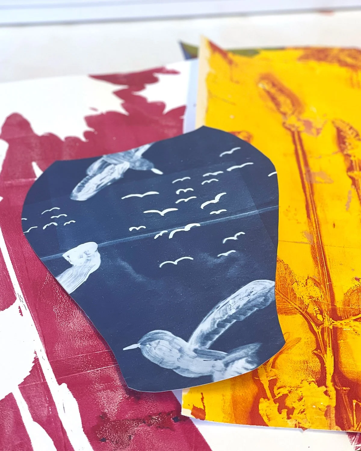 Gelli plate-tryckta papper i blått, magenta och gult.