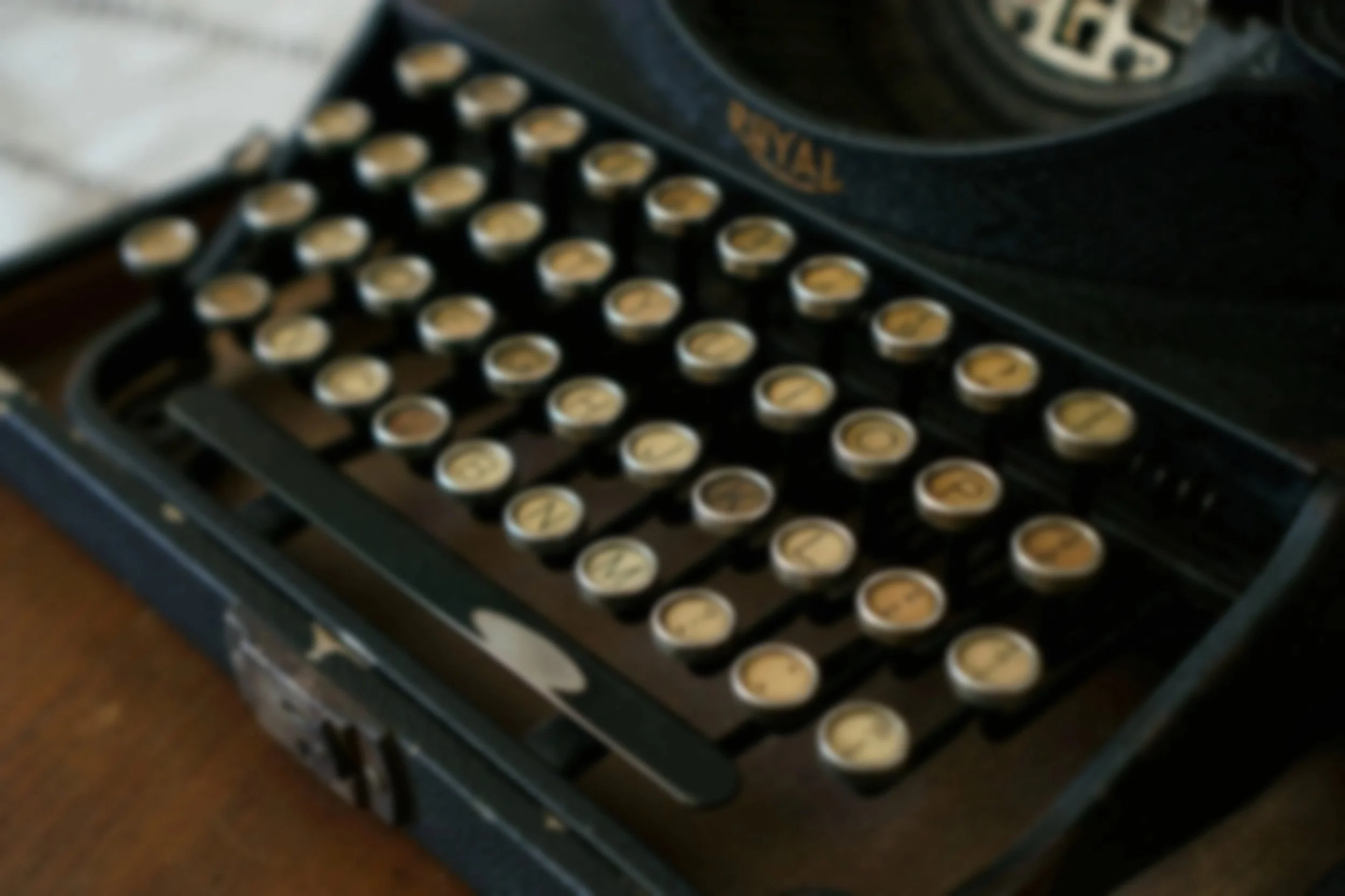A vintage typewriter with round keys and a black body.