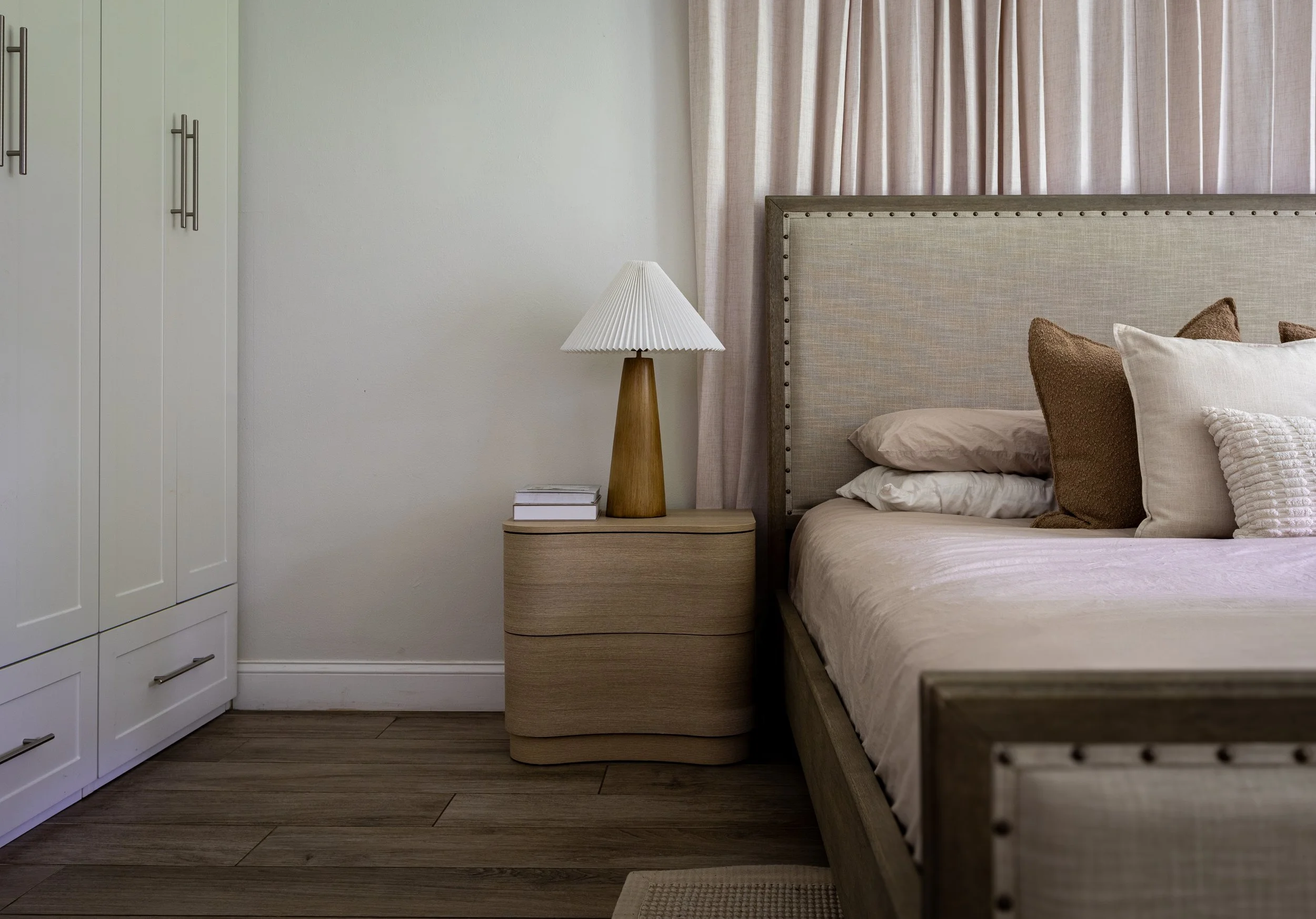 Modern luxury bedroom with warm neutral palette and natural lighting.