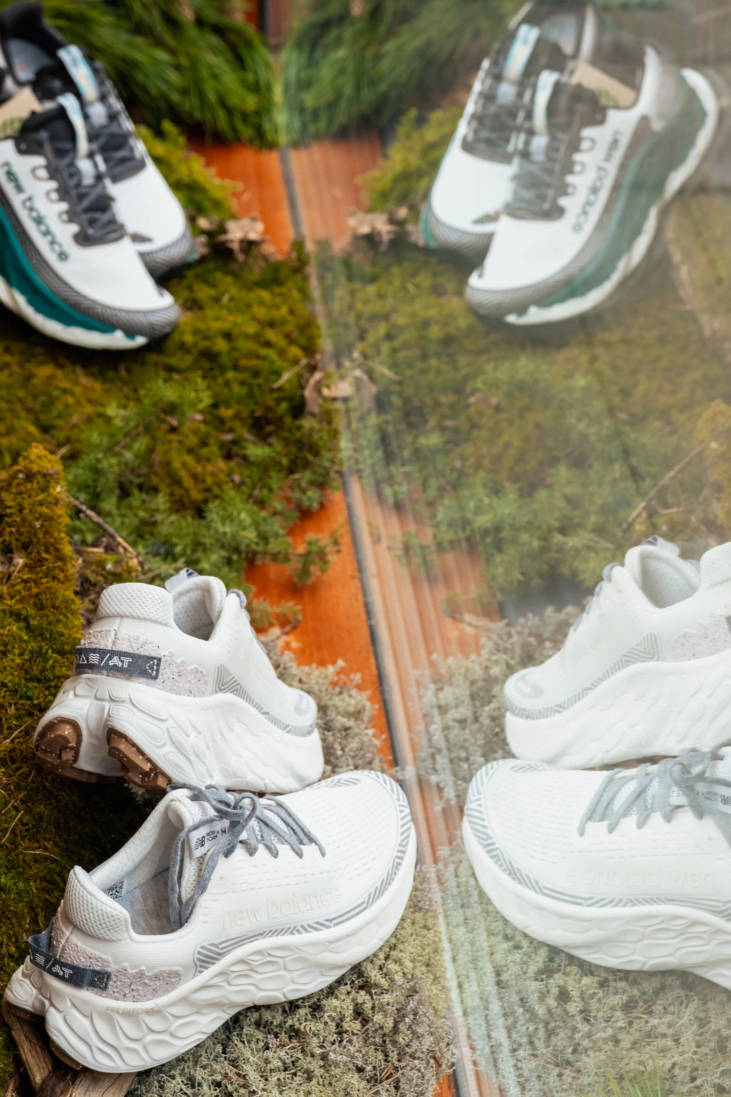 Trail shoes styled on moss and wood at the New Balance pop-up