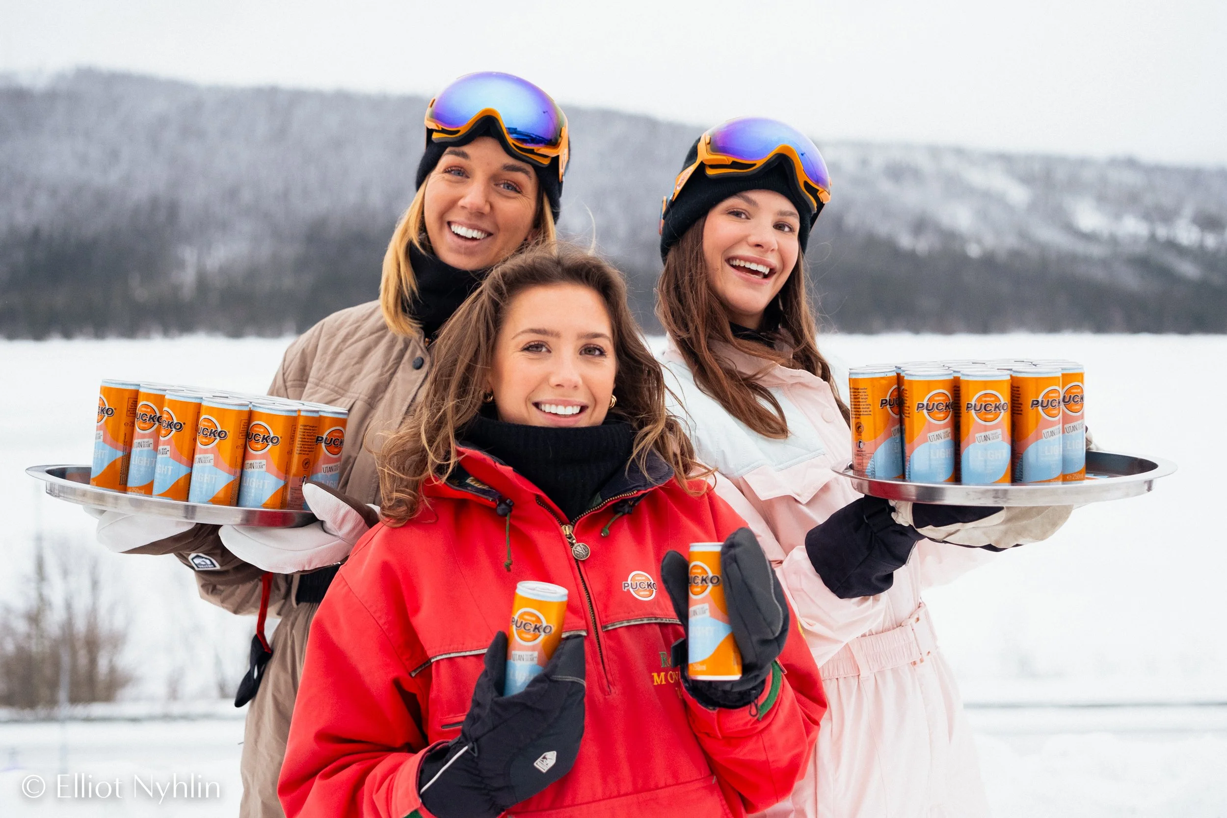 Women in ski gear handing out drinks in the snow at SkiWeek Åre