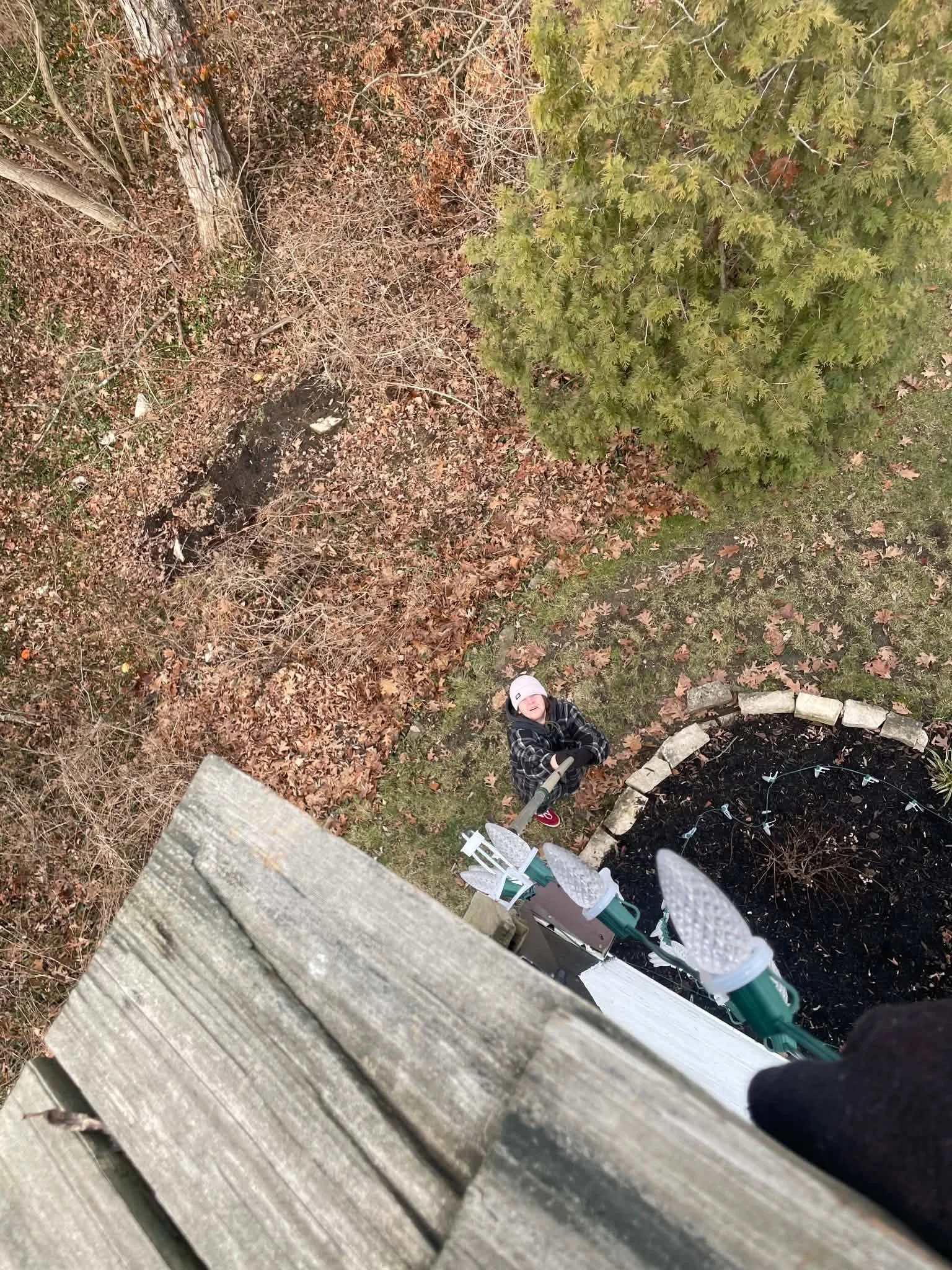 Installer working from a roofline during professional Christmas light installation in Dayton, Ohio.