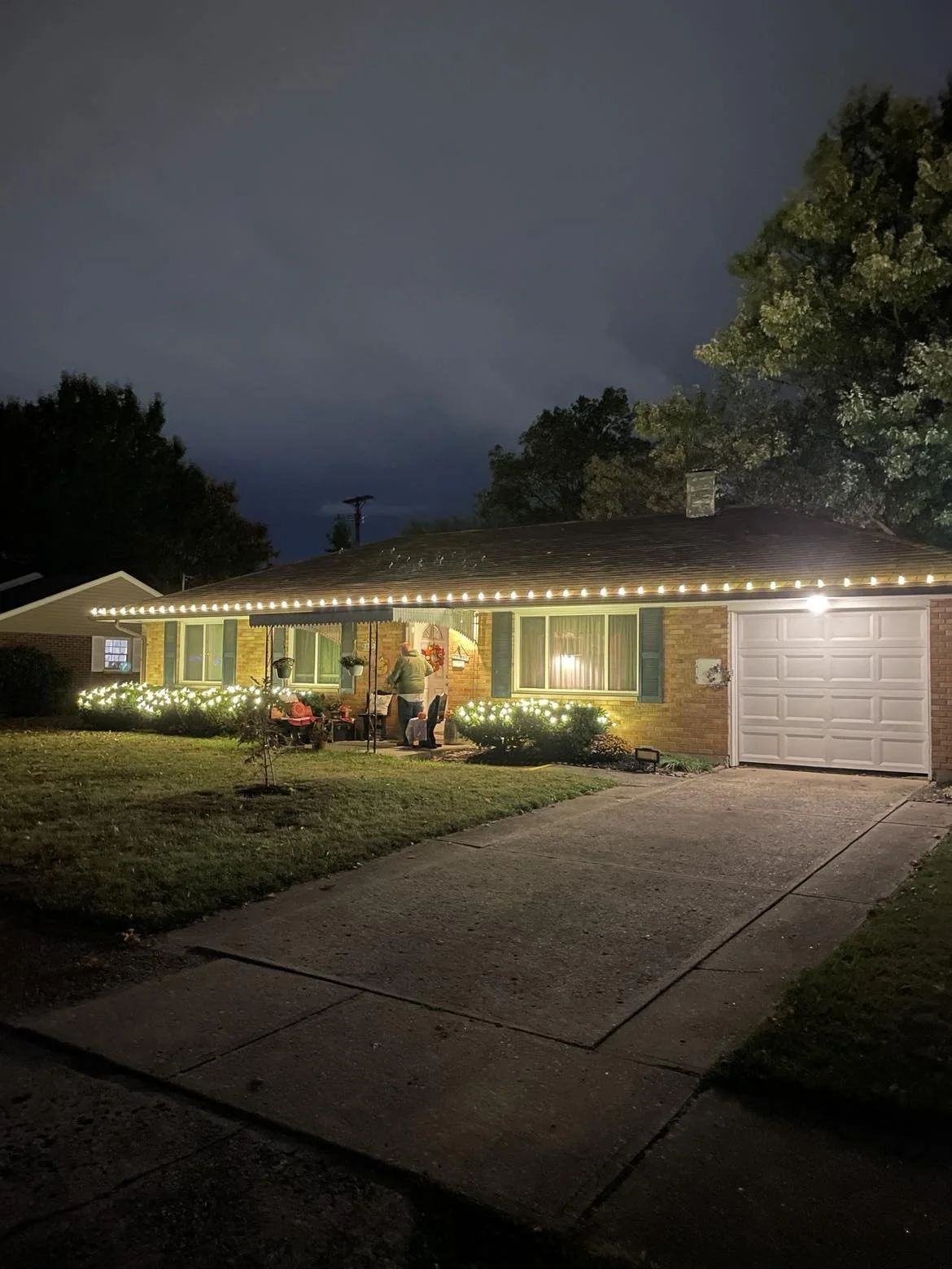 Completed residential Christmas light installation with warm white roofline and landscape lighting in Dayton, Ohio.