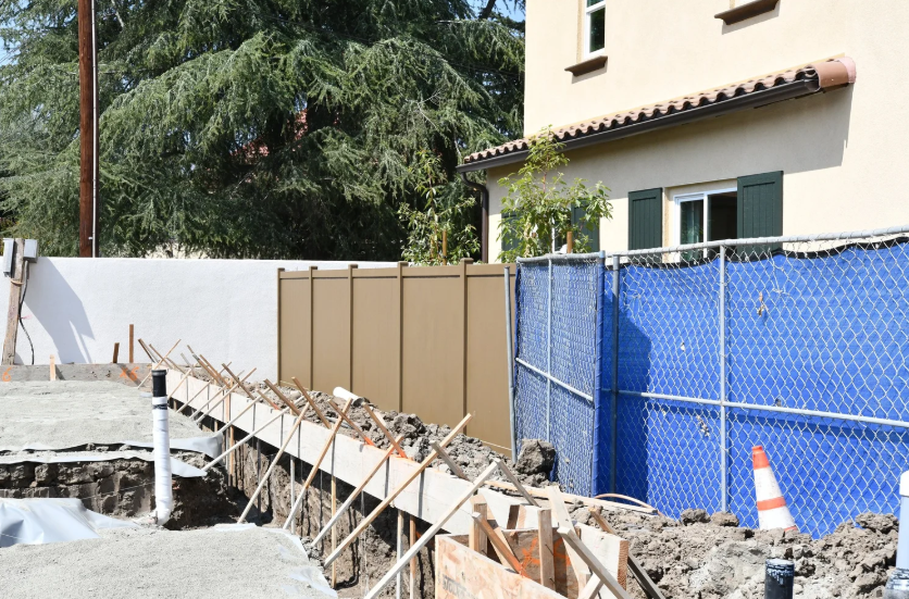 Residential privacy fence next to a construction site illustrating building code requirements.