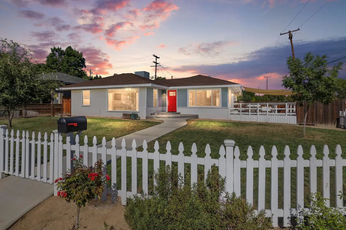 01 Front Area - Charming Home with Red Door and White Picket Fence at Sunset.jpg