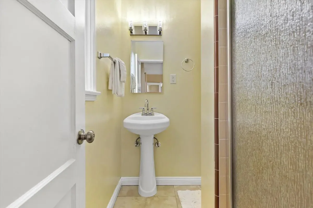 12 PRIMARY Bathroom 01 - Cozy and Functional Bathroom with Pedestal Sink.jpg