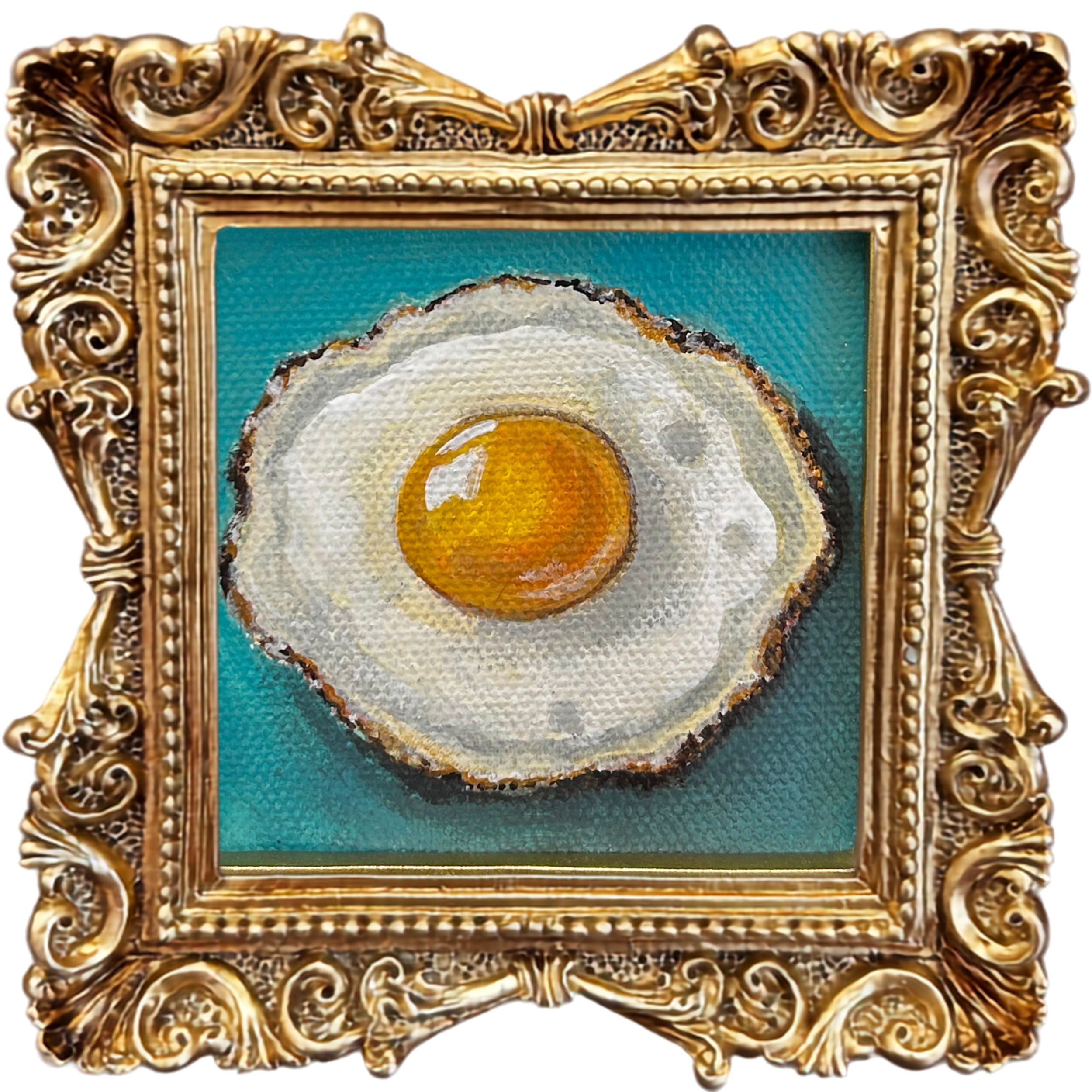 Close-up of an ornate, gold, decorative picture frame with an artwork of a fried egg.