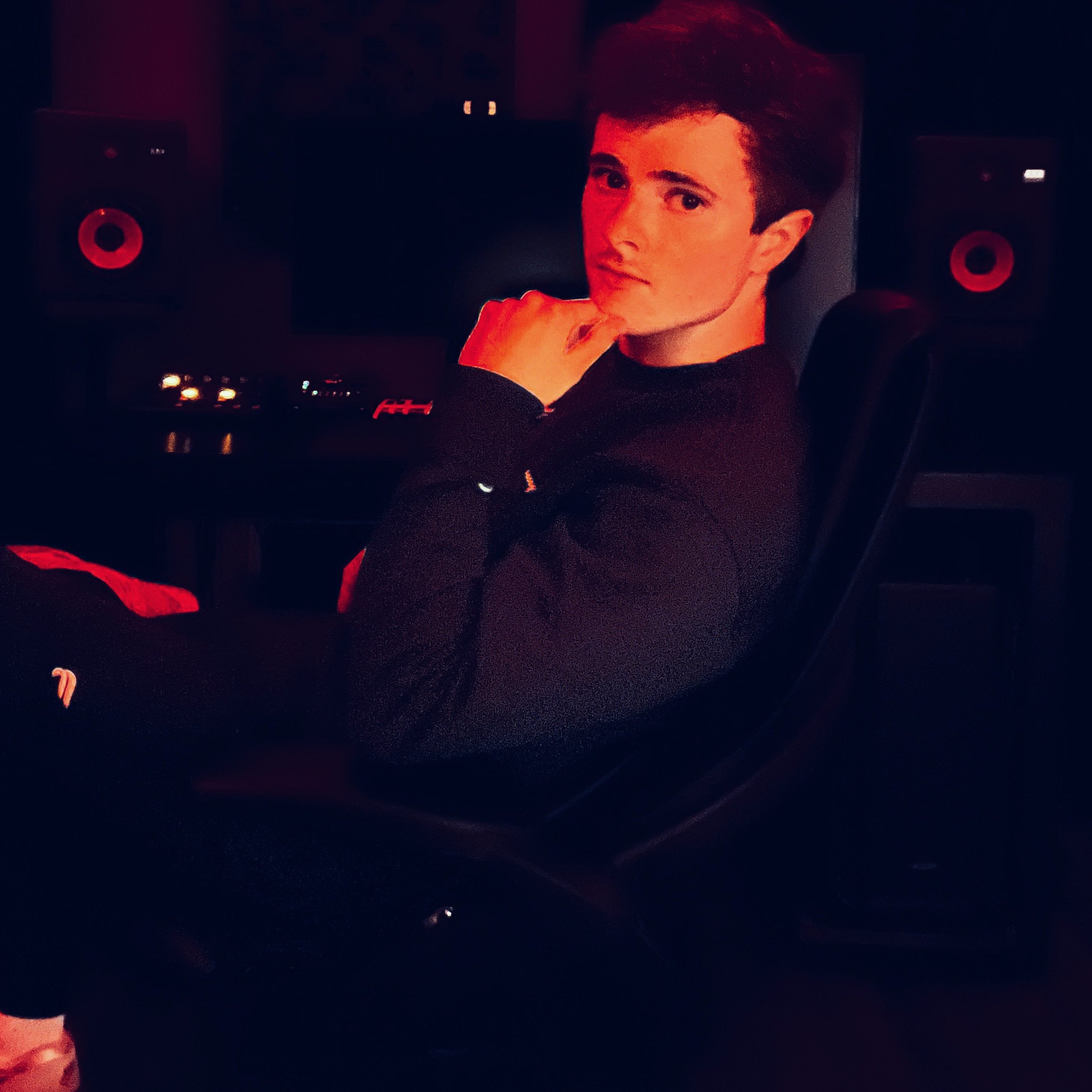Jesse Samples in Music Studio Chair in front of speakers