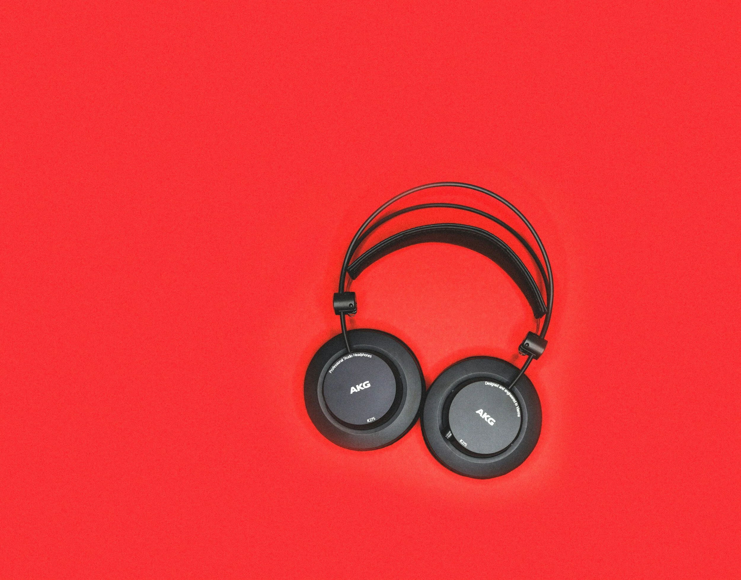 Black over ear headphones on a red background