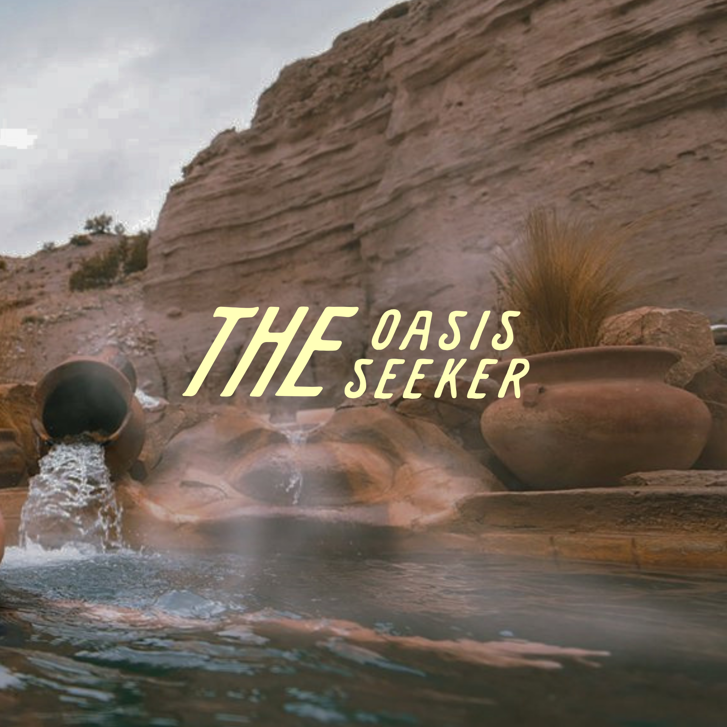 Natural rock pool with cascading water beneath a red sandstone cliff, labeled “The Oasis Seeker.”