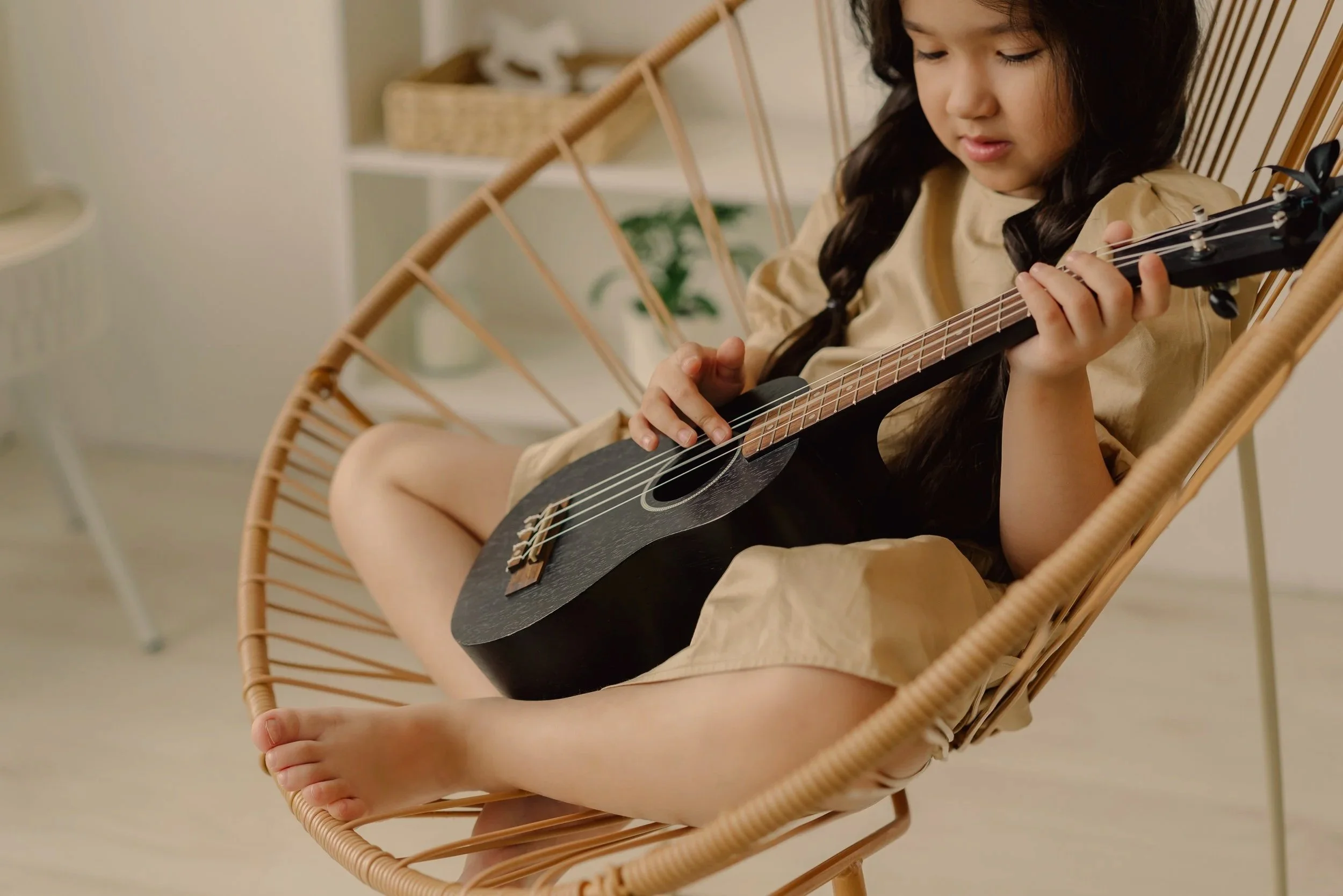 Enfant québécoise chantant une comptine avec une guitare pour développer son langage et sa conscience phonologique.