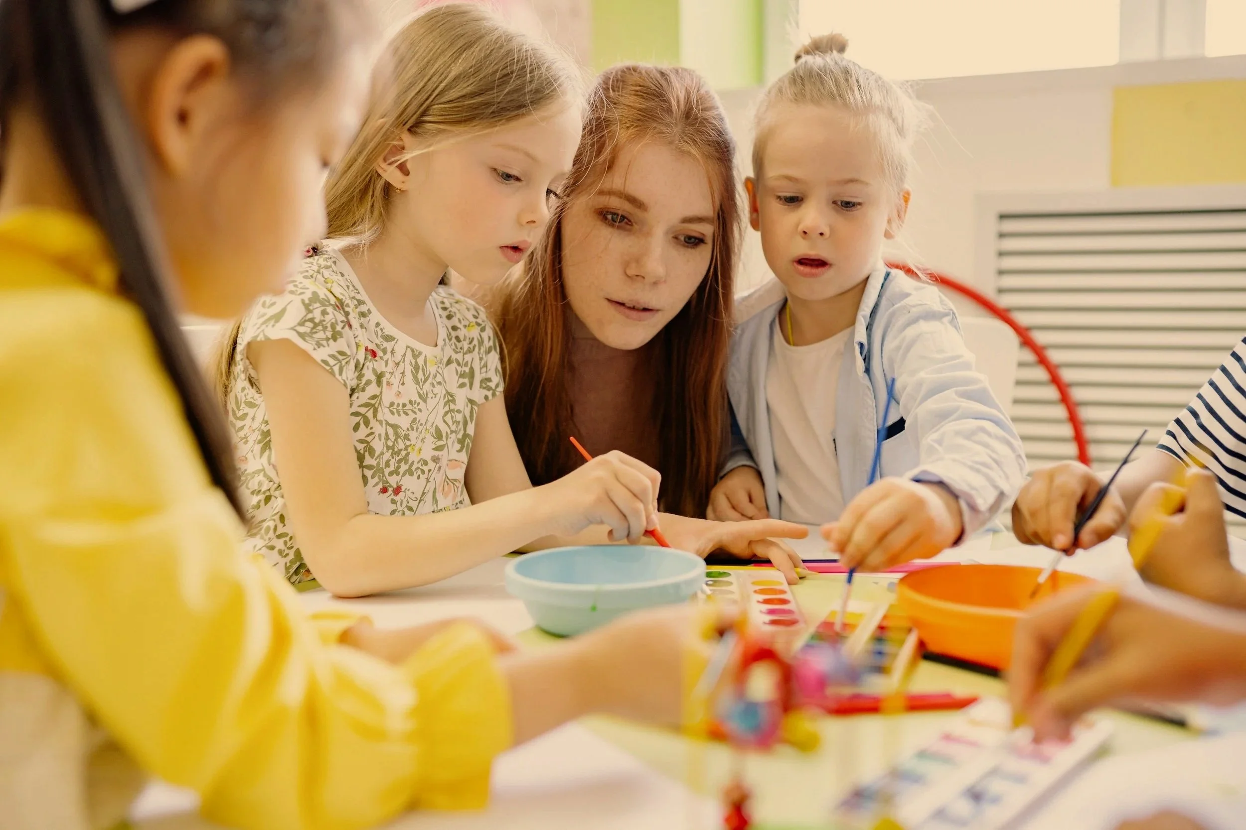 Éducatrice en service de garde à la hauteur d'un enfant qui communique spontanément pendant le jeu