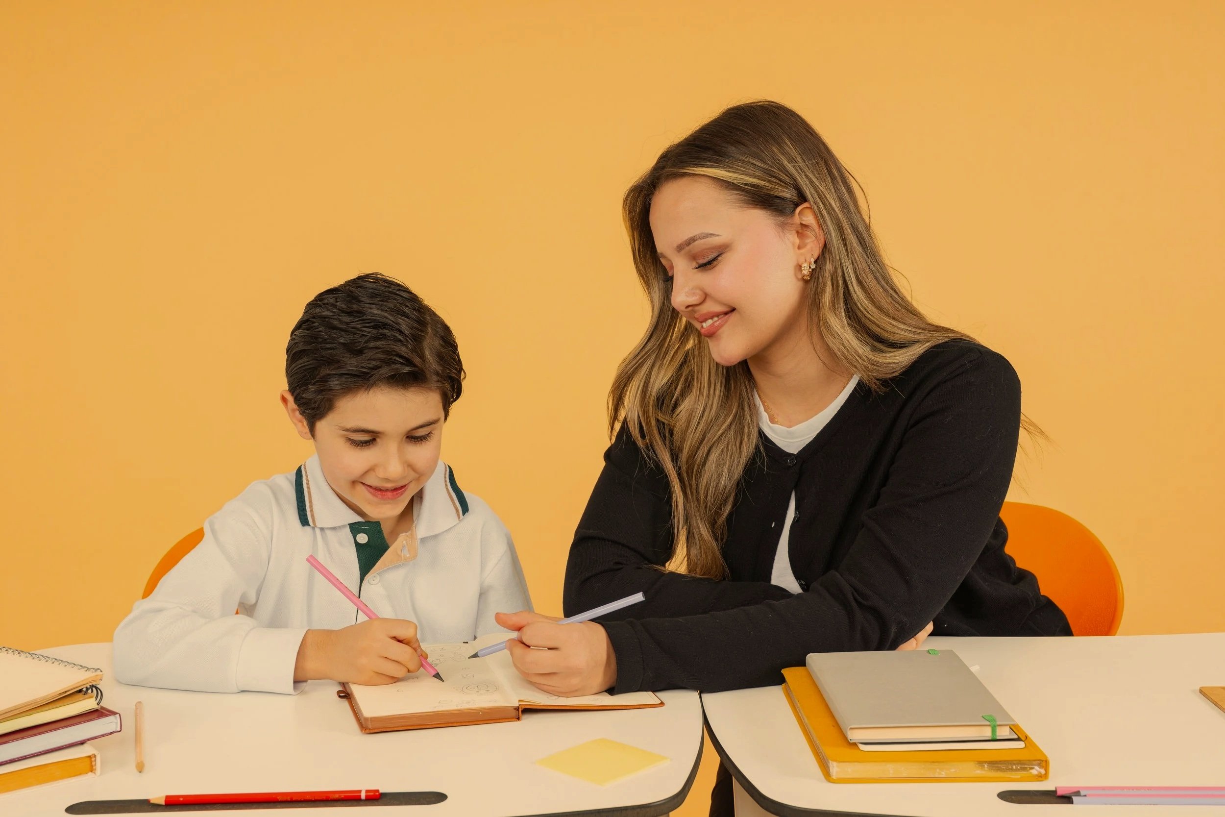 Une orthophoniste est assise à une table face à un enfant (4-6 ans). Elle lui montre des images ou un jeu spécifique pour tester son vocabulaire. L'enfant est concentré et répond. L'ambiance est calme et professionnelle.