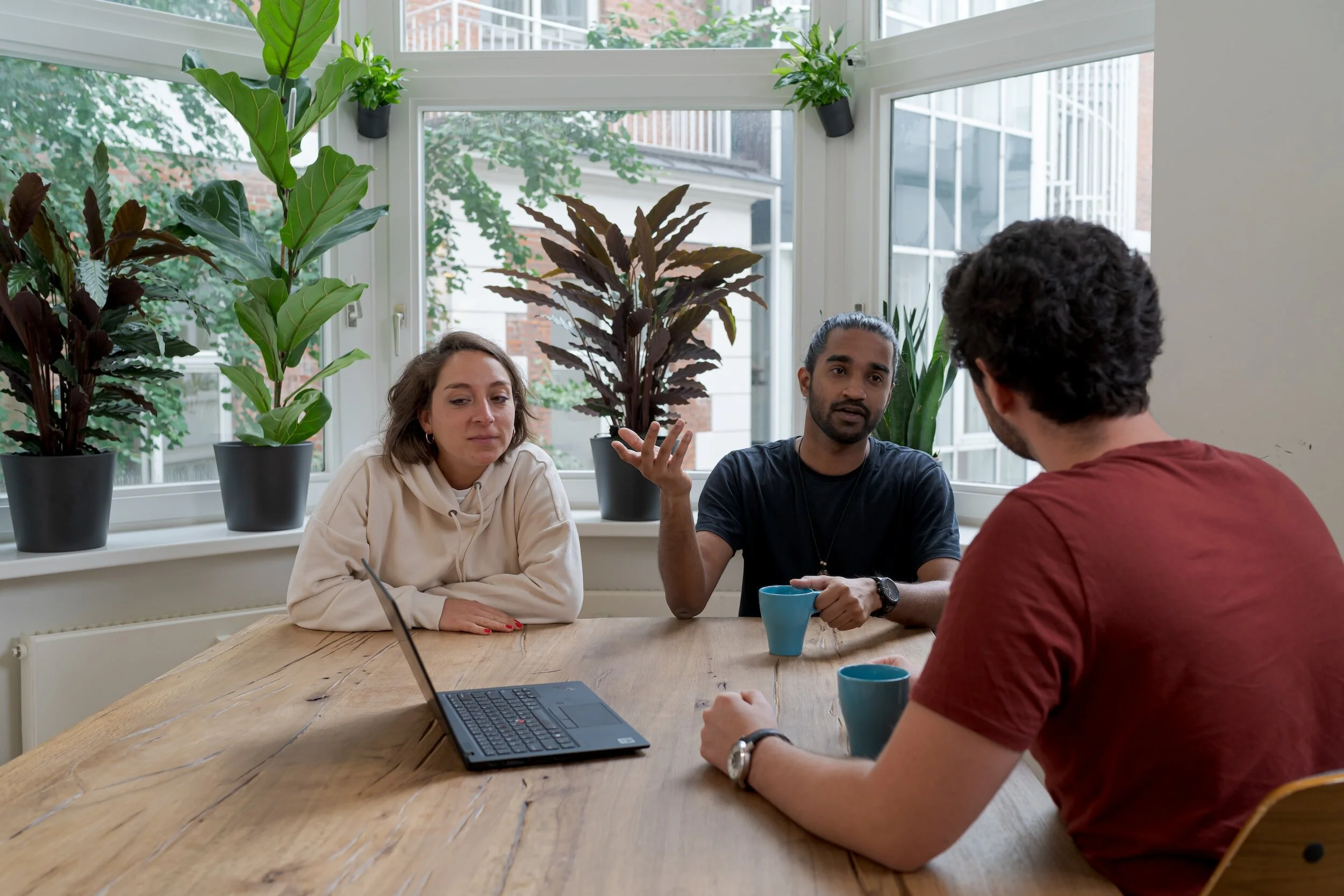 Three people speaking at a table