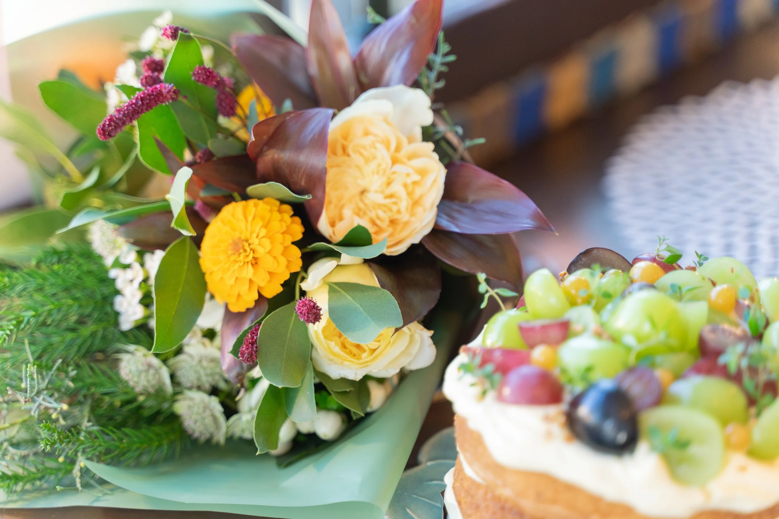 A set of a yellow flower bouquet and a grape anniversary cake