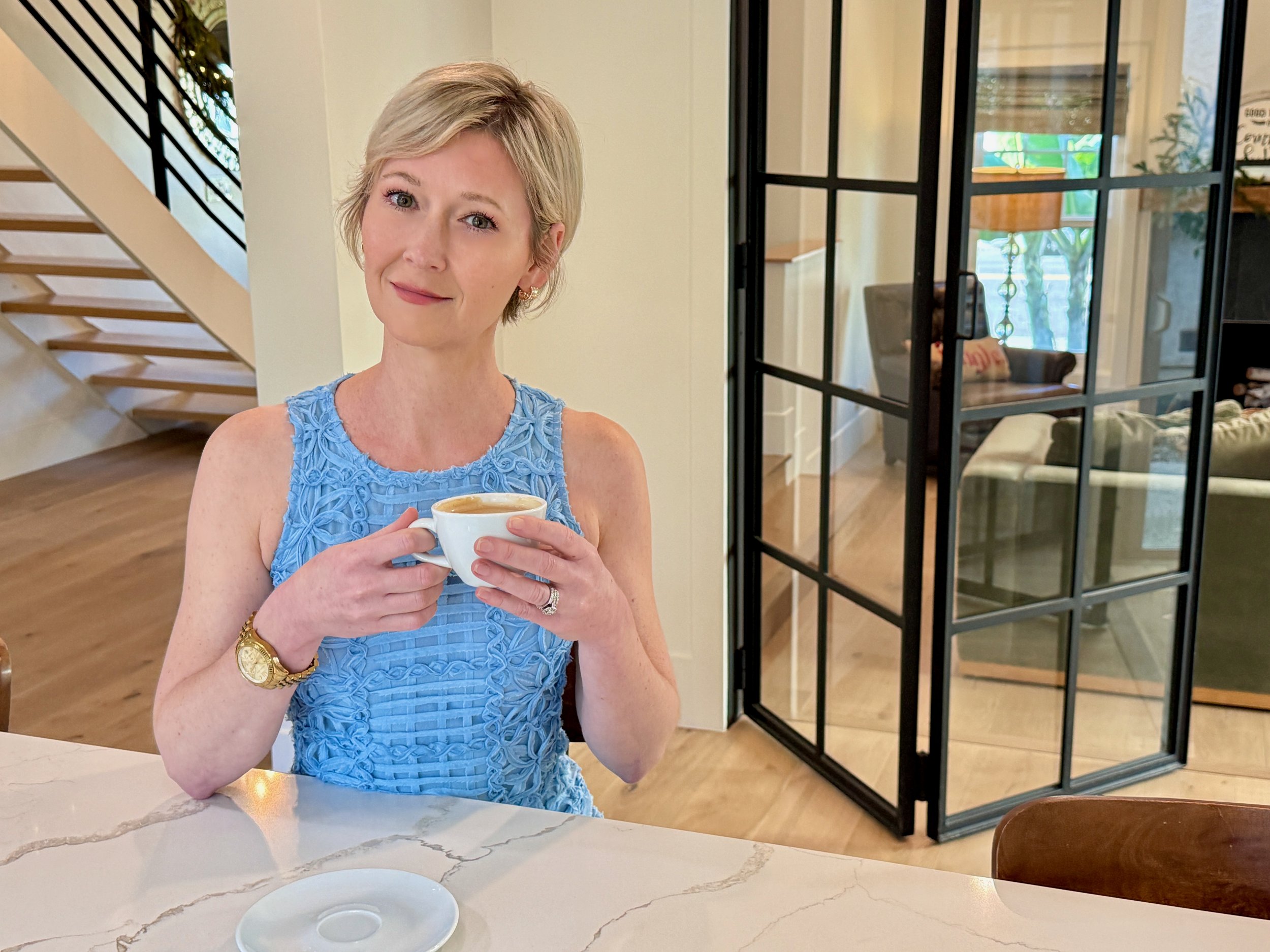 Ashlee Lynn Espinosa sitting peacefully by a fire pit surrounded by palm trees, reflecting on creativity and clarity.