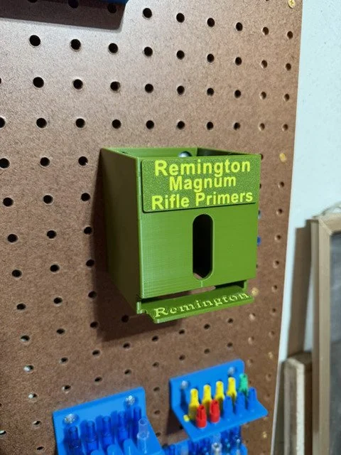 Wall- or bench-mounted Remington Magnum Rifle primer pack organizer with five vertical storage slots and included mounting hardware.