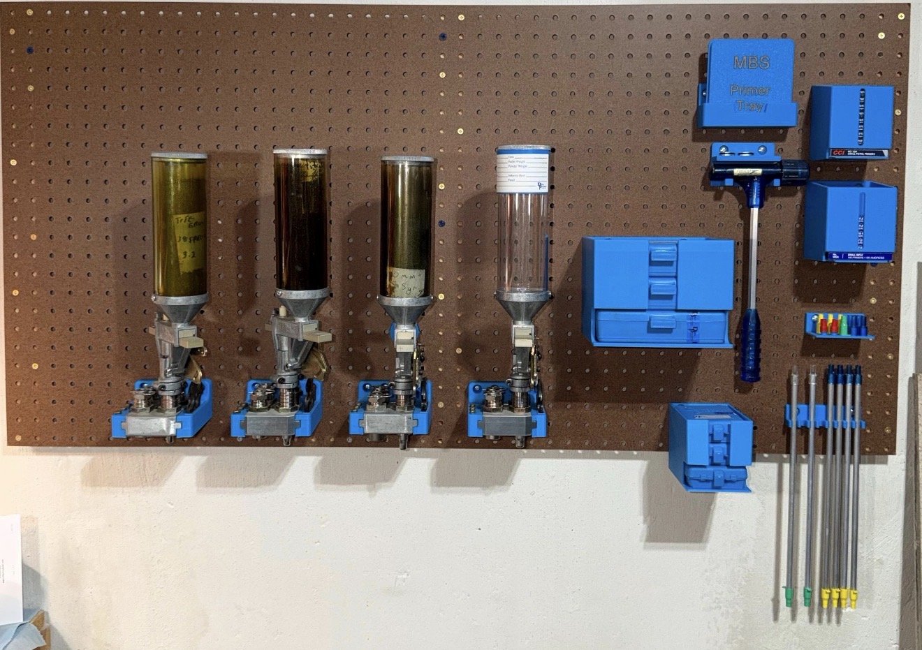 Multiple Dillon reloading accessories mounted on pegboard for organization.