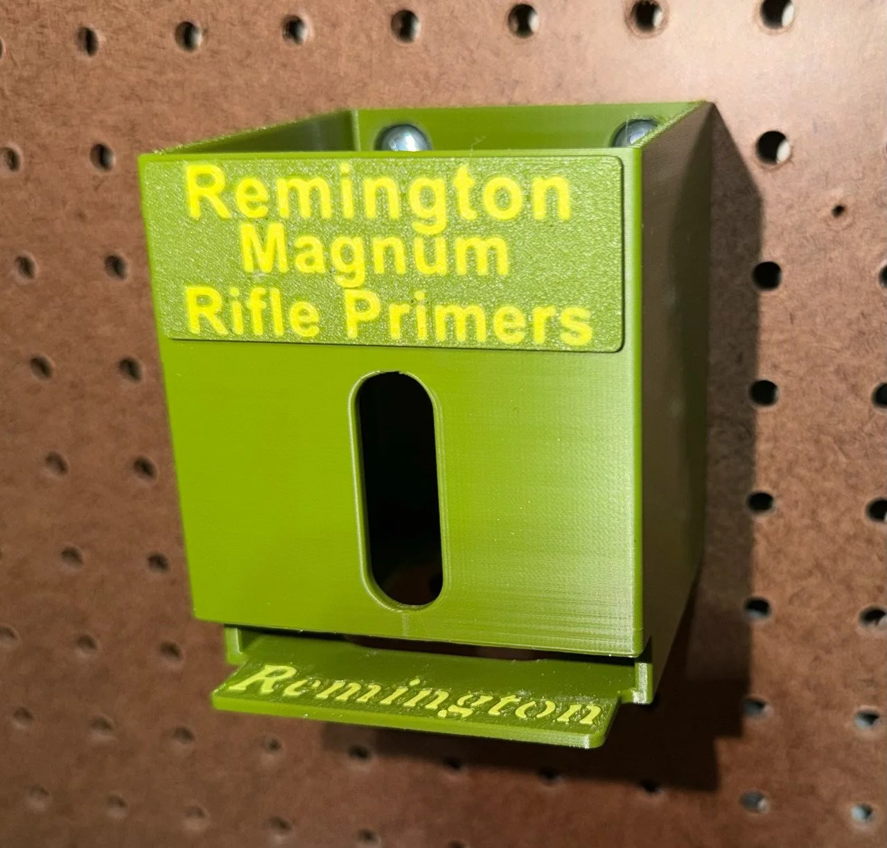 Durable five-pack reloading-bench organizer for Remington Magnum Rifle primer packs, compatible with plastic and compressed pegboard.