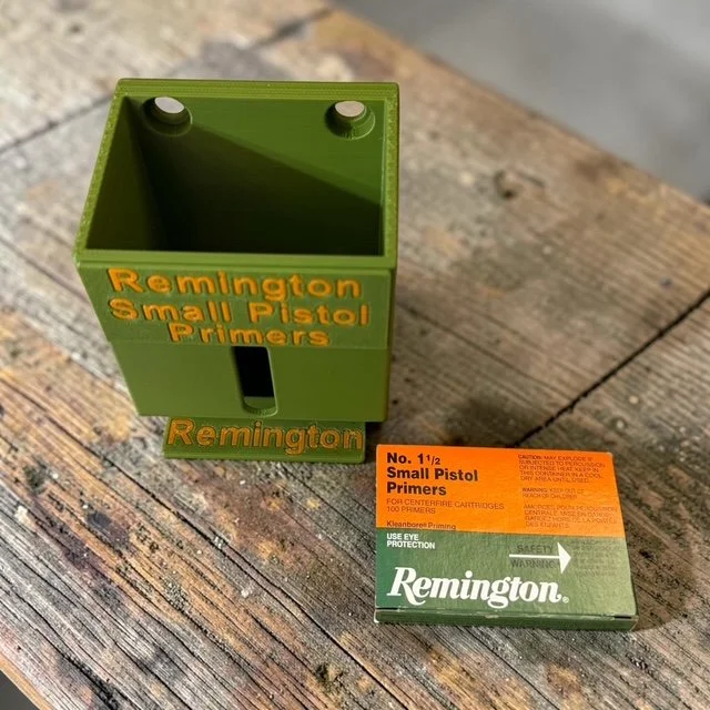 Remington Small Pistol Primer Pack Organizer on a wooden surface next to one No. 1 1/2 primer pack.