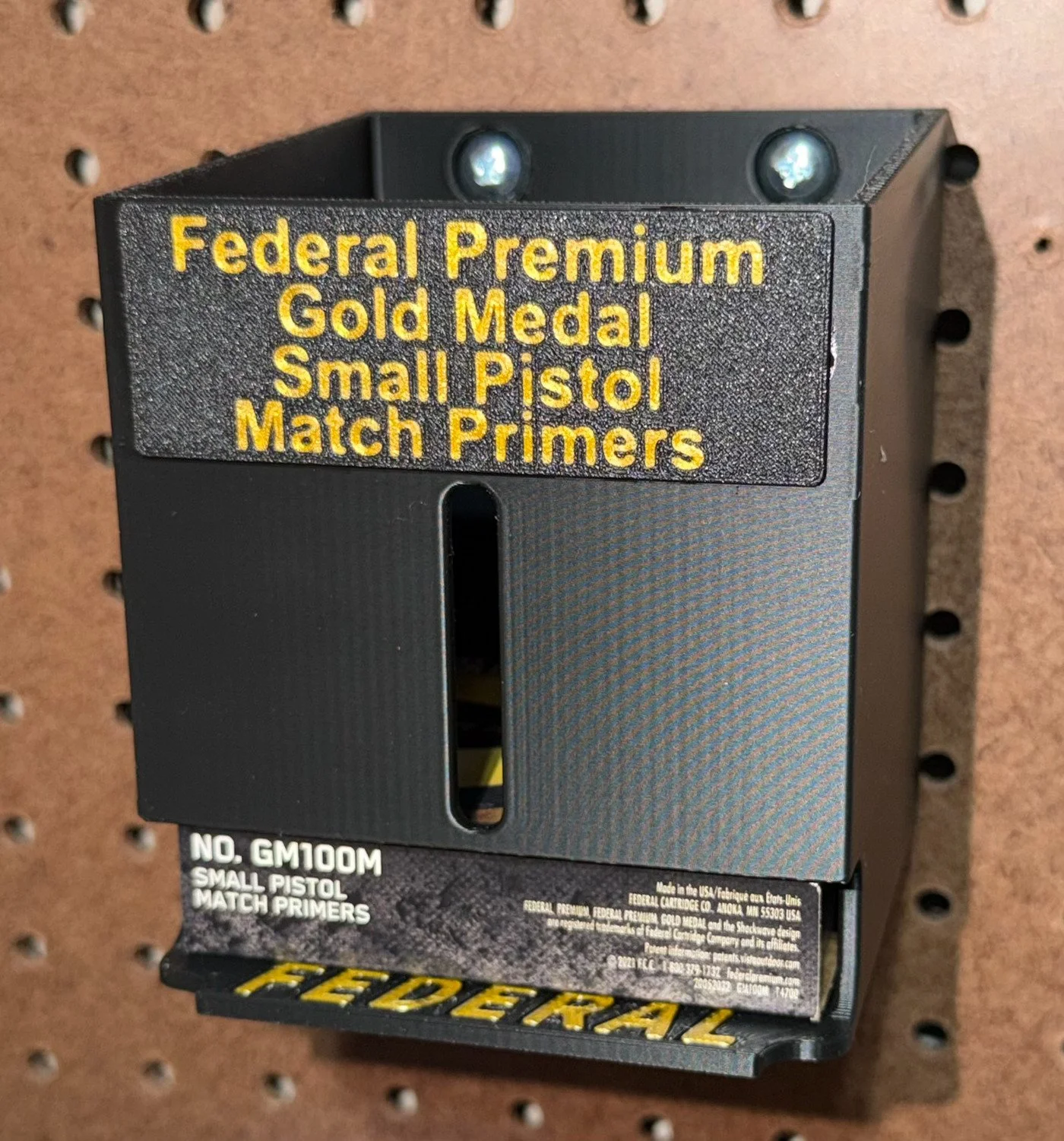 Small pistol match primer pack organizer mounted on a pegboard with Federal primer packs.