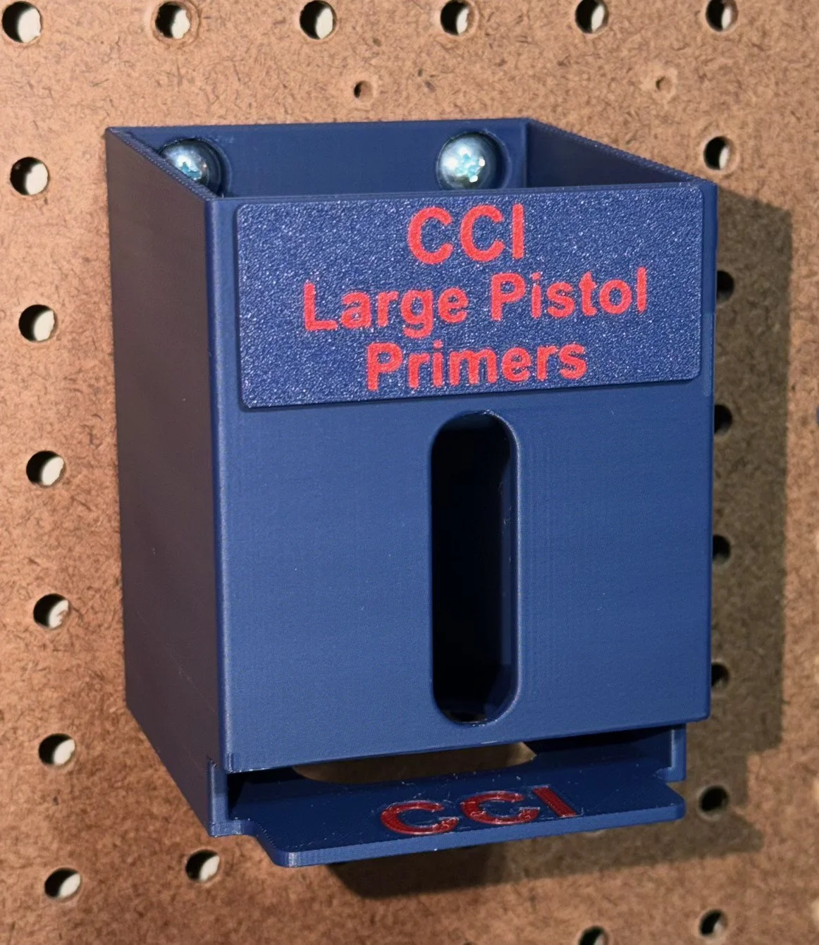 Empty CCI Large Pistol Primer Pack Organizer mounted on pegboard, ready for loading.