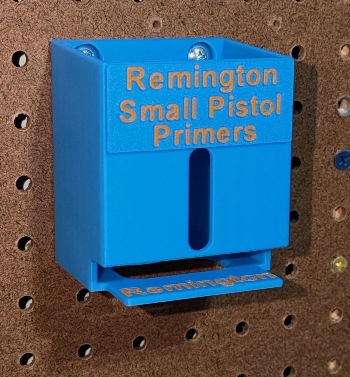 Remington small pistol primer pack organizer mounted on pegboard, waiting to hold and dispense primer packs.