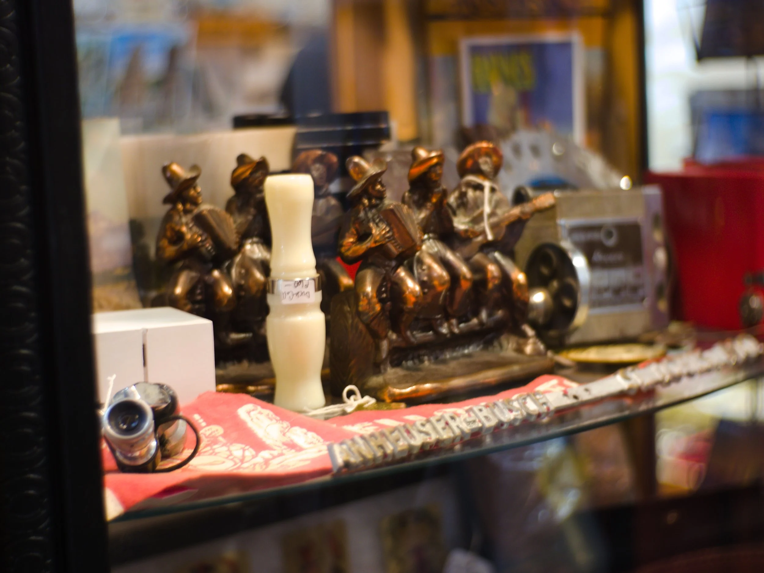 Colorful various figurines and objects displayed on a glass shelf at a store.
