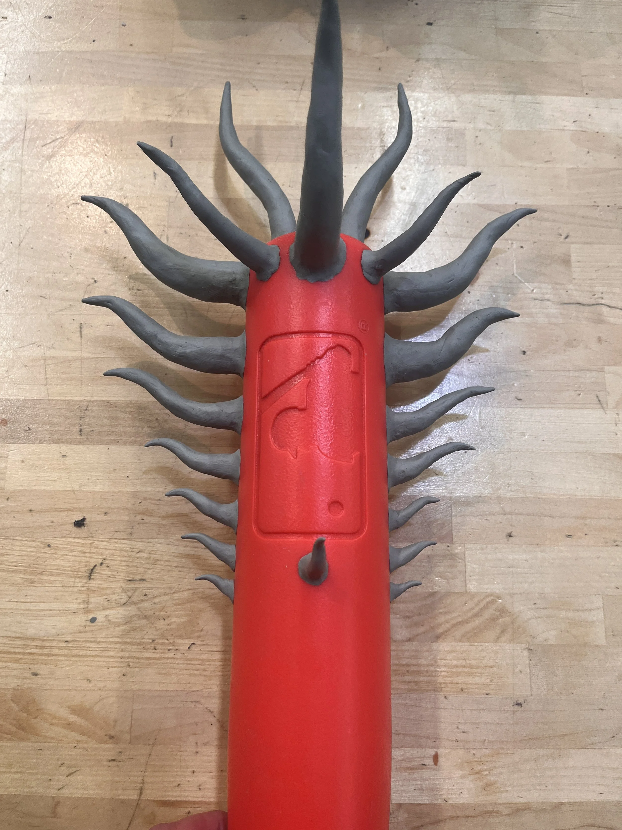 A red and gray toy resembling a creature with multiple tentacle-like appendages.