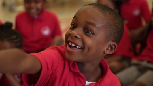 A young child smiling in a classroom