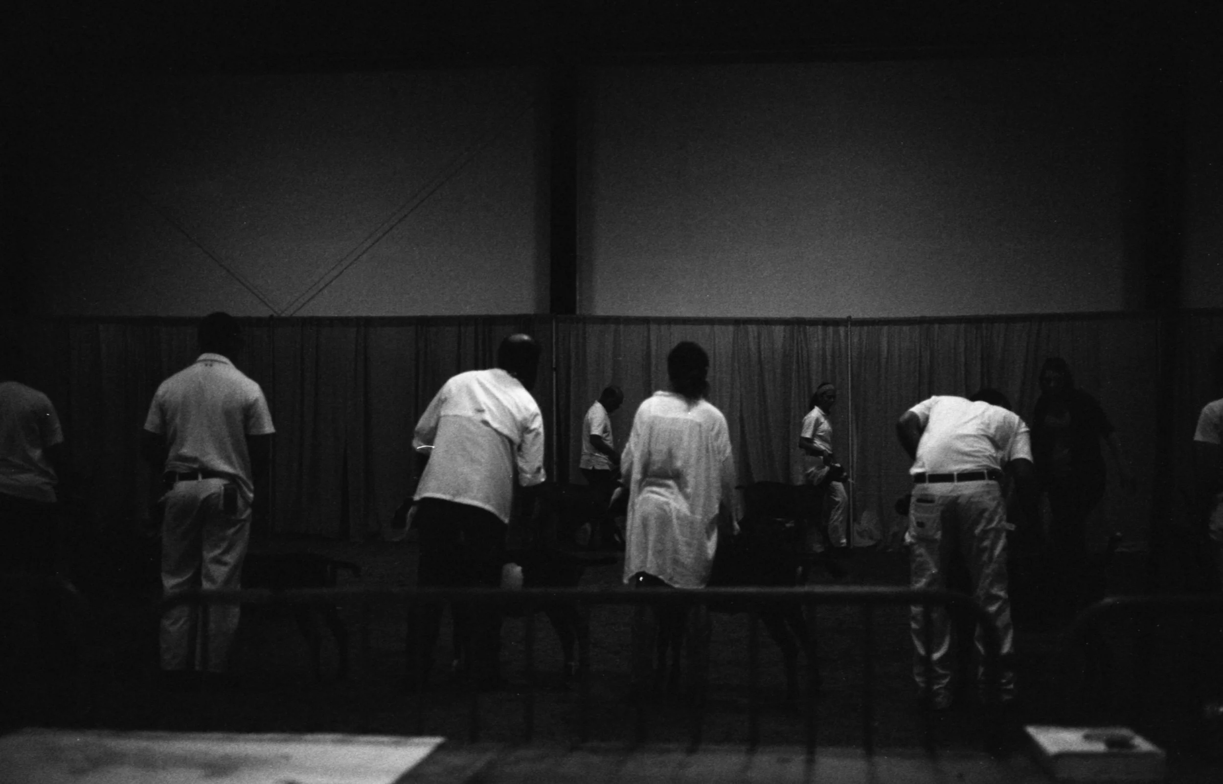 Black and white images of the back of people all wearing white tops