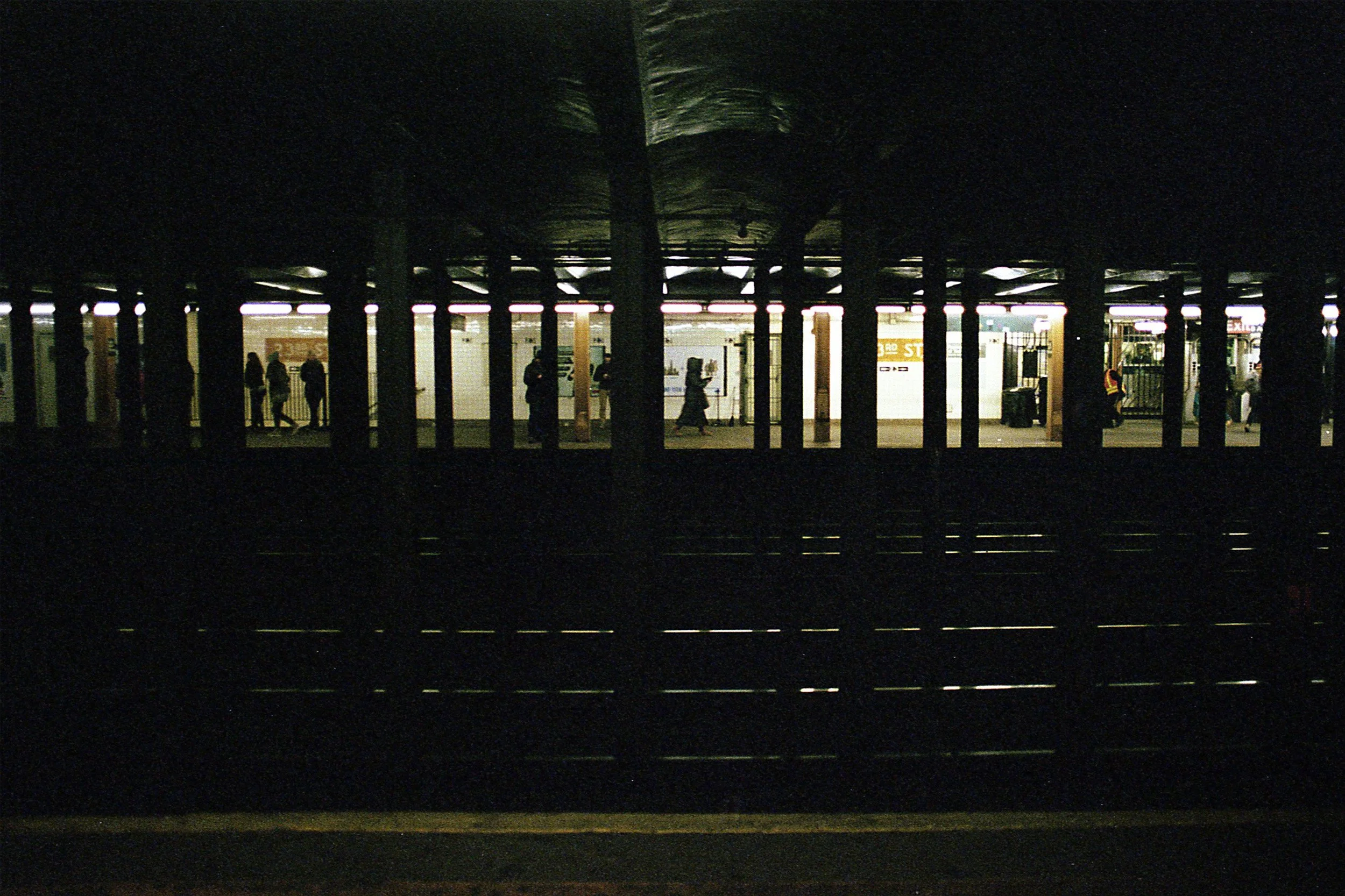 color photo of figures moving along a train platform