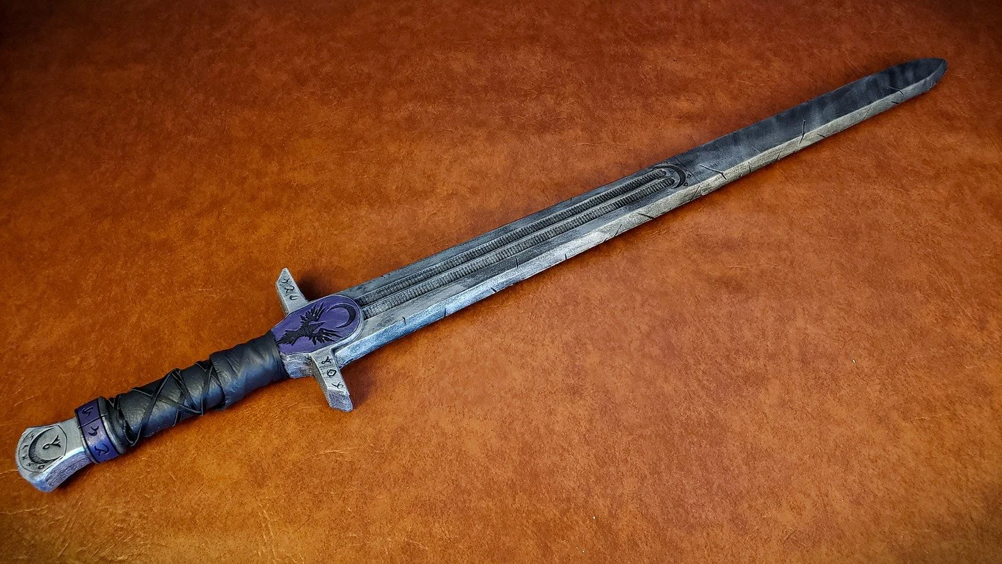An oldie but a goodie, and still my go-to fantasy sword. This prop was made for myself for my time at Twin Mask, a LARP in Southern California! The motif was spellsword, adding runes and house symbols, with splotches of purple, black and silver to de