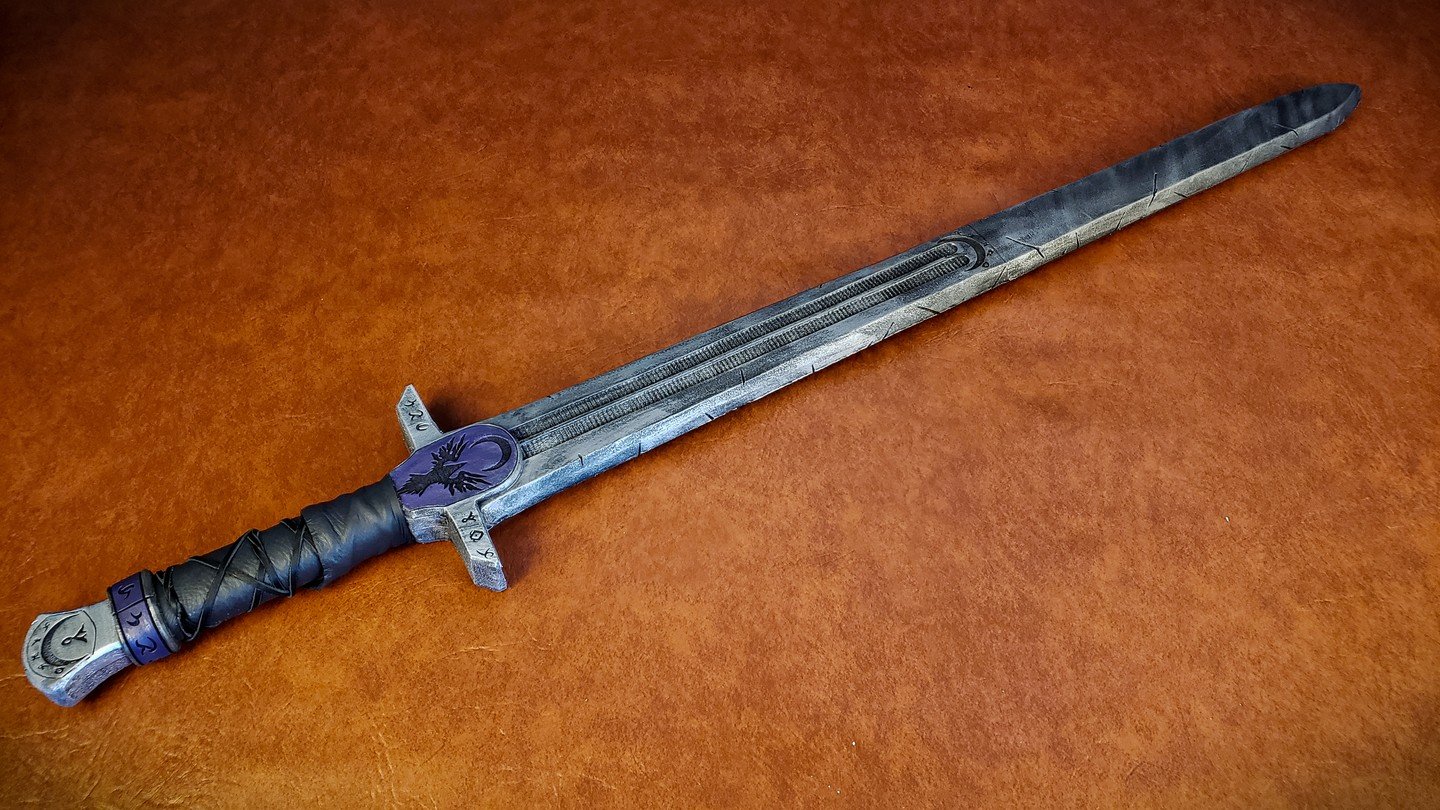 An oldie but a goodie, and still my go-to fantasy sword. This prop was made for myself for my time at Twin Mask, a LARP in Southern California! The motif was spellsword, adding runes and house symbols, with splotches of purple, black and silver to de