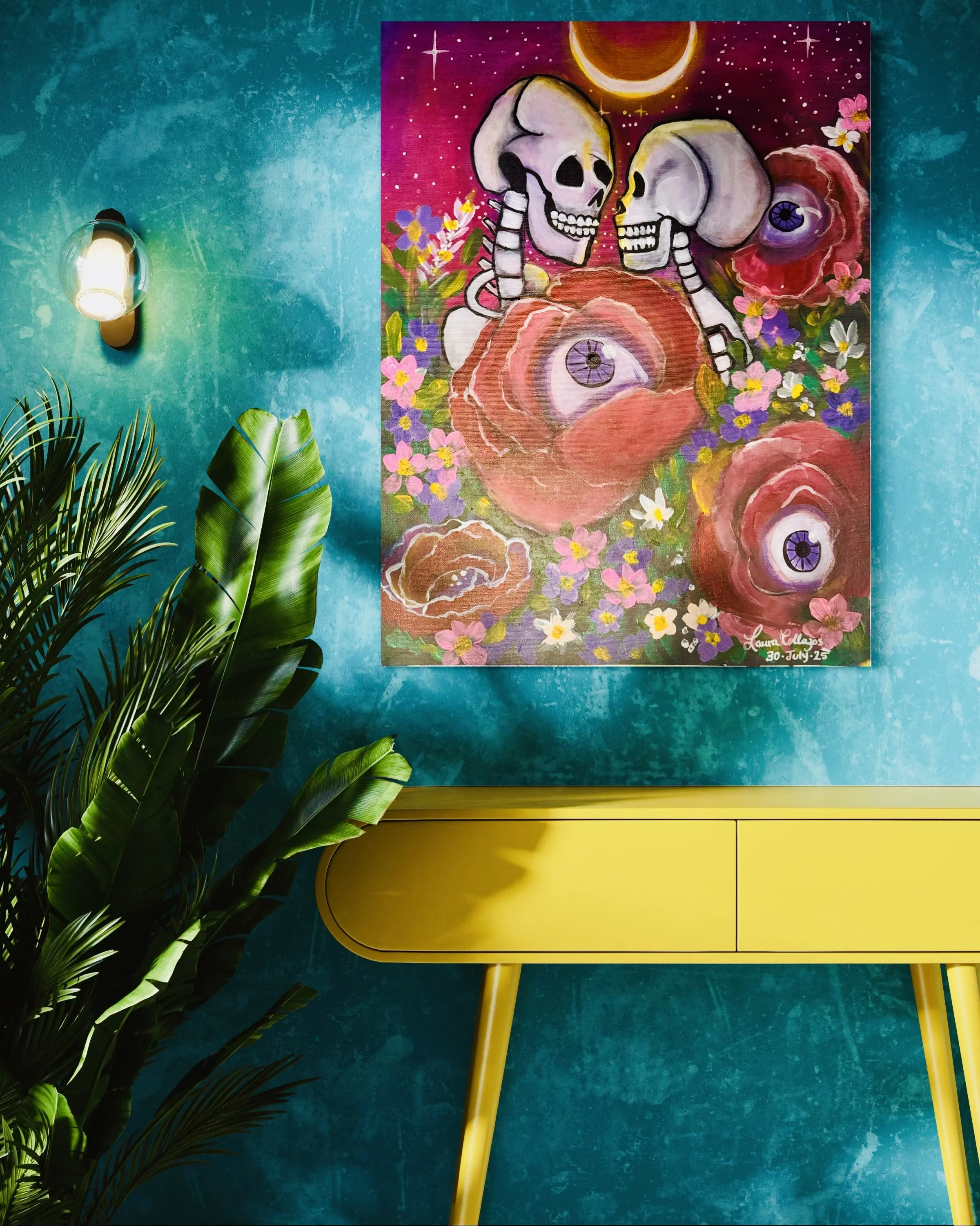 Colorful painting of two skulls with flowers and large flowers with eyeballs on a purple and pink background, signed by Laura Eldos, displayed on a teal textured wall with a yellow sideboard and green plants.