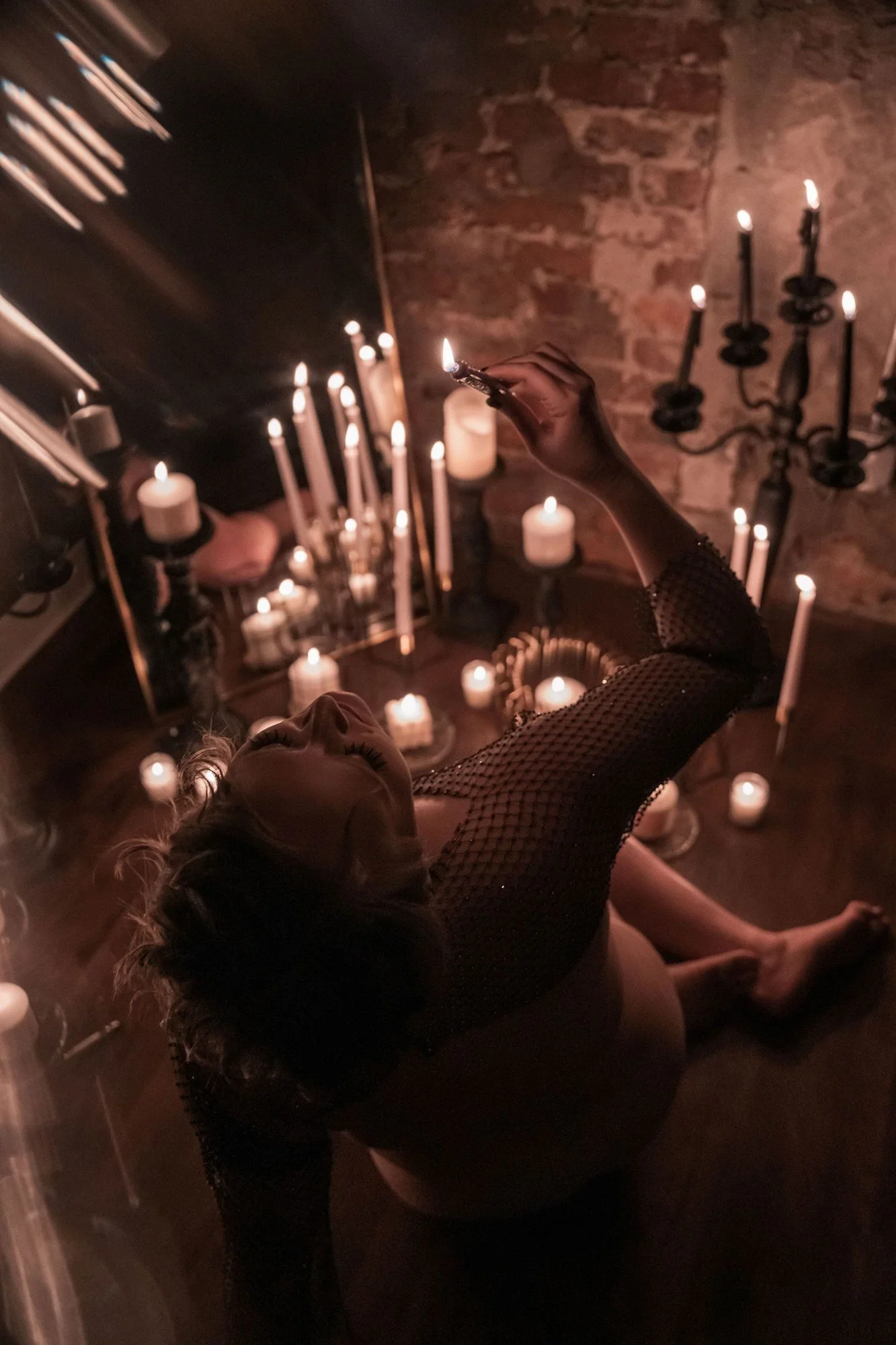 Woman reaching toward a candelabra in warm candlelight, Candle Light add-on set by Nashville boudoir photographer Holly Douglas & Co