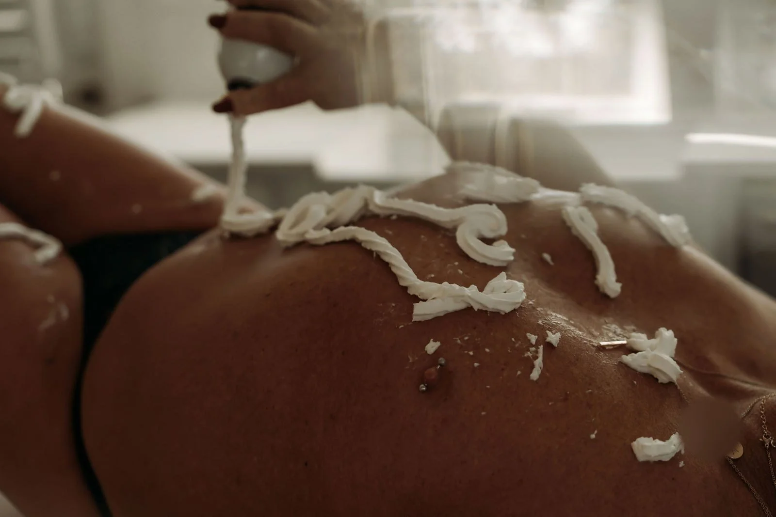 Whipped cream swirls across bare skin in warm light, Sticky Sweet boudoir photos, Nashville