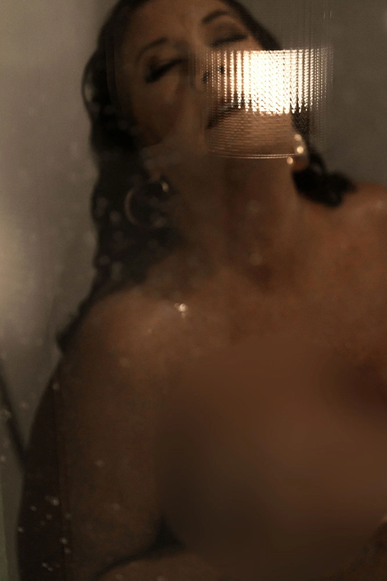 Close-up of a woman behind steamy glass with water on her skin, Nashville boudoir add-on sets