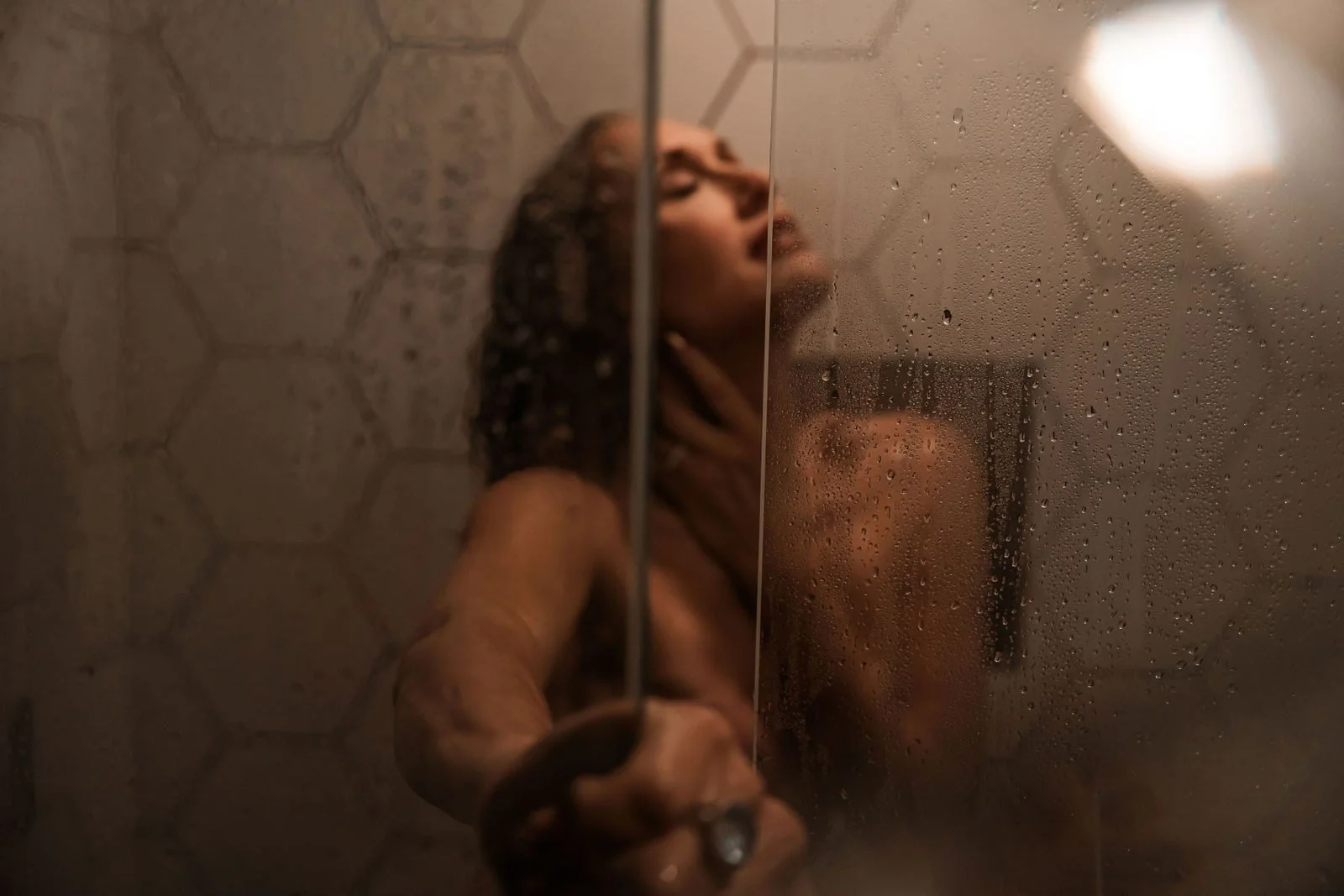 Woman tilting her head back in a steamy tiled shower, nude boudoir add-on by Nashville boudoir photographer Holly Douglas & Co