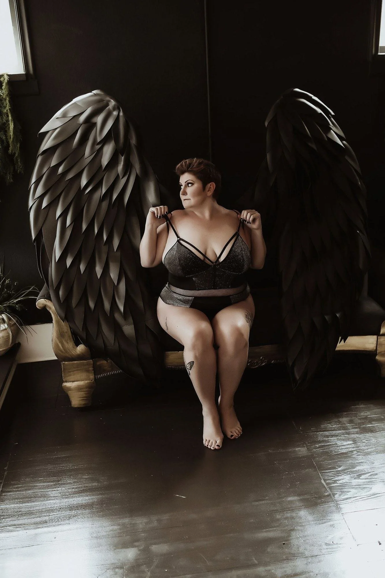 Woman in black lingerie seated in front of large silver angel wings, Angel Wings add-on set by Nashville boudoir photographer Holly Douglas & Co