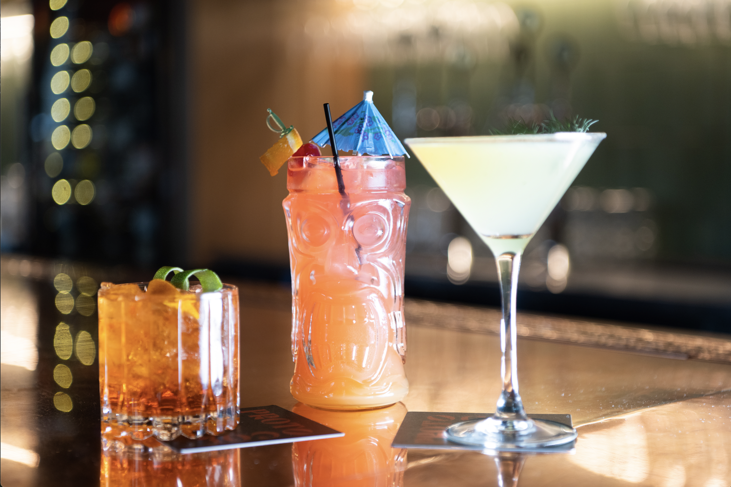 Three colorful craft cocktails on the bar at Protocol