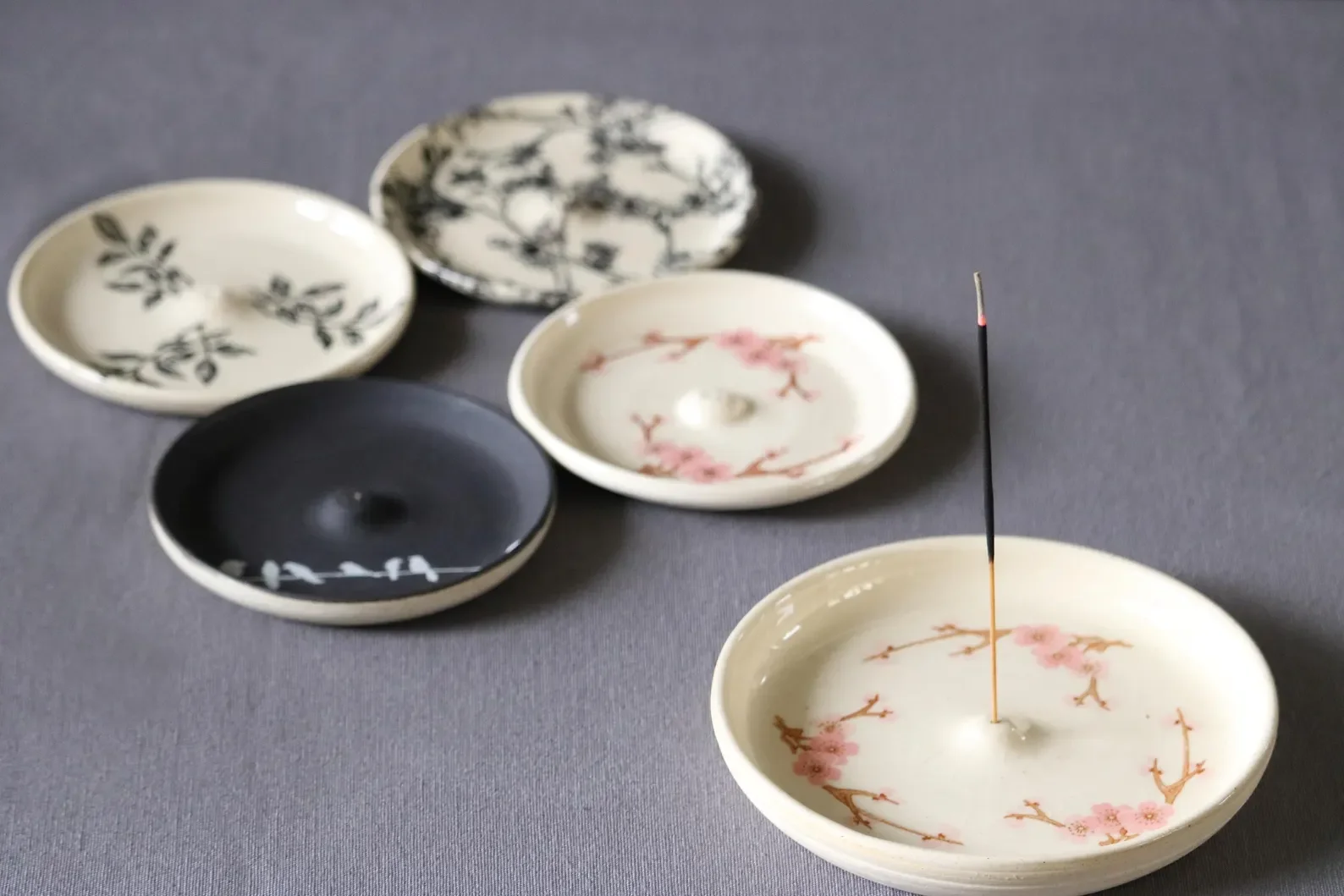 Handmade ceramic incense holders with botanical and nature-inspired prints.