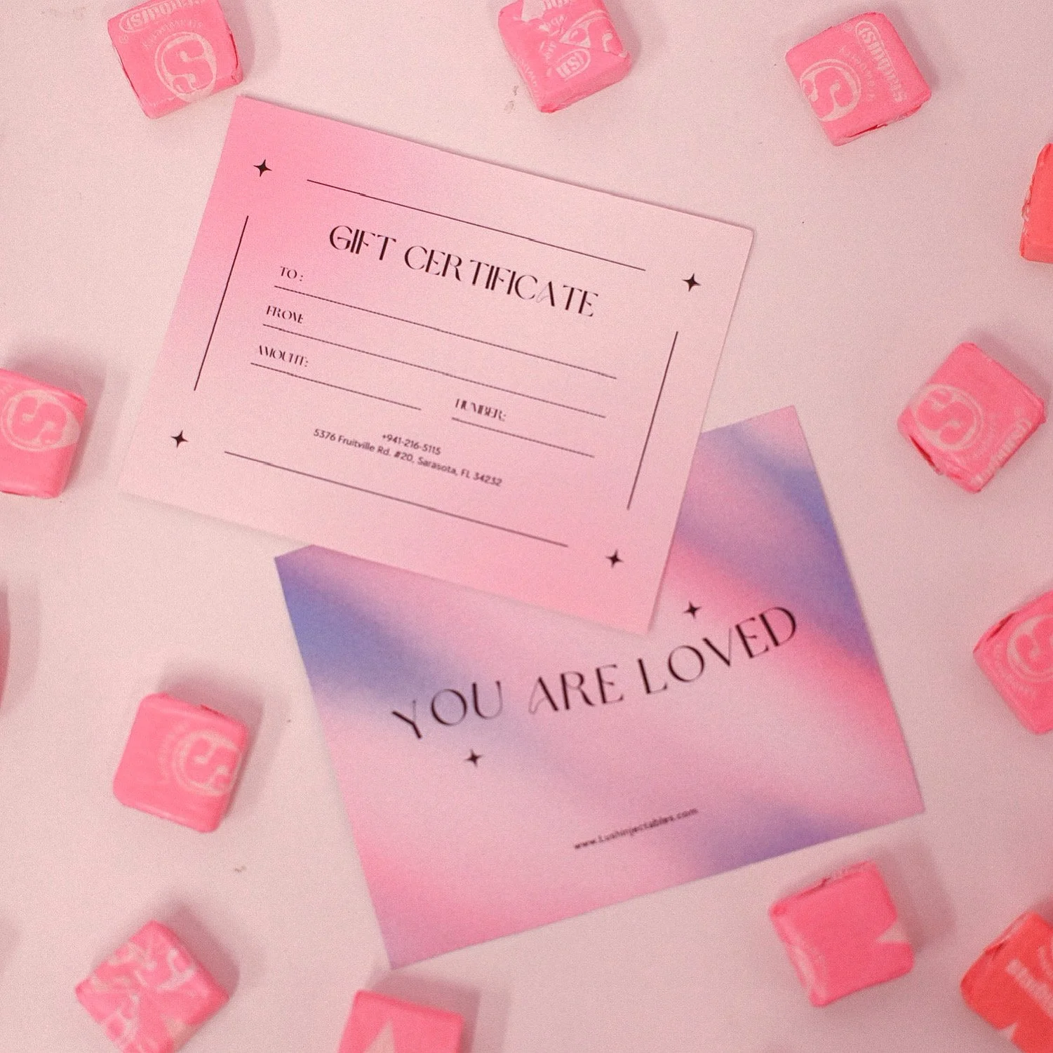 Gift certificate and "You Are Loved" card with pink candy on a white background.