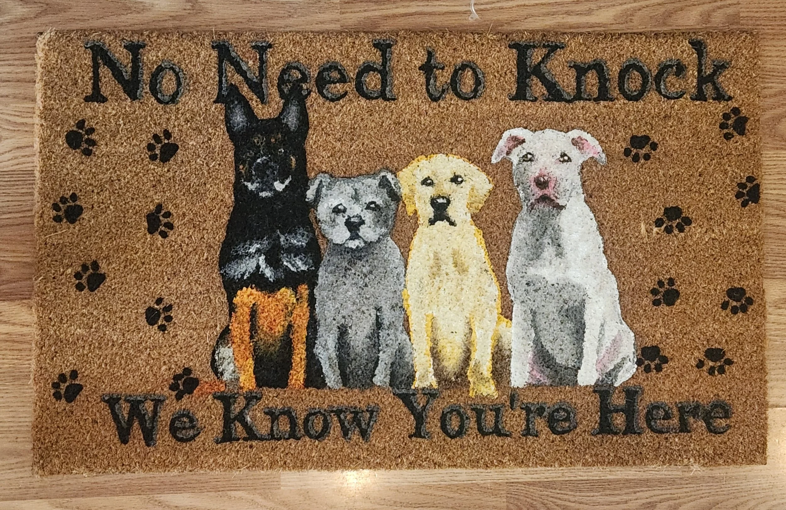 Doormat with four different dog breeds and the words "No Need to Knock, We Know You're Here"