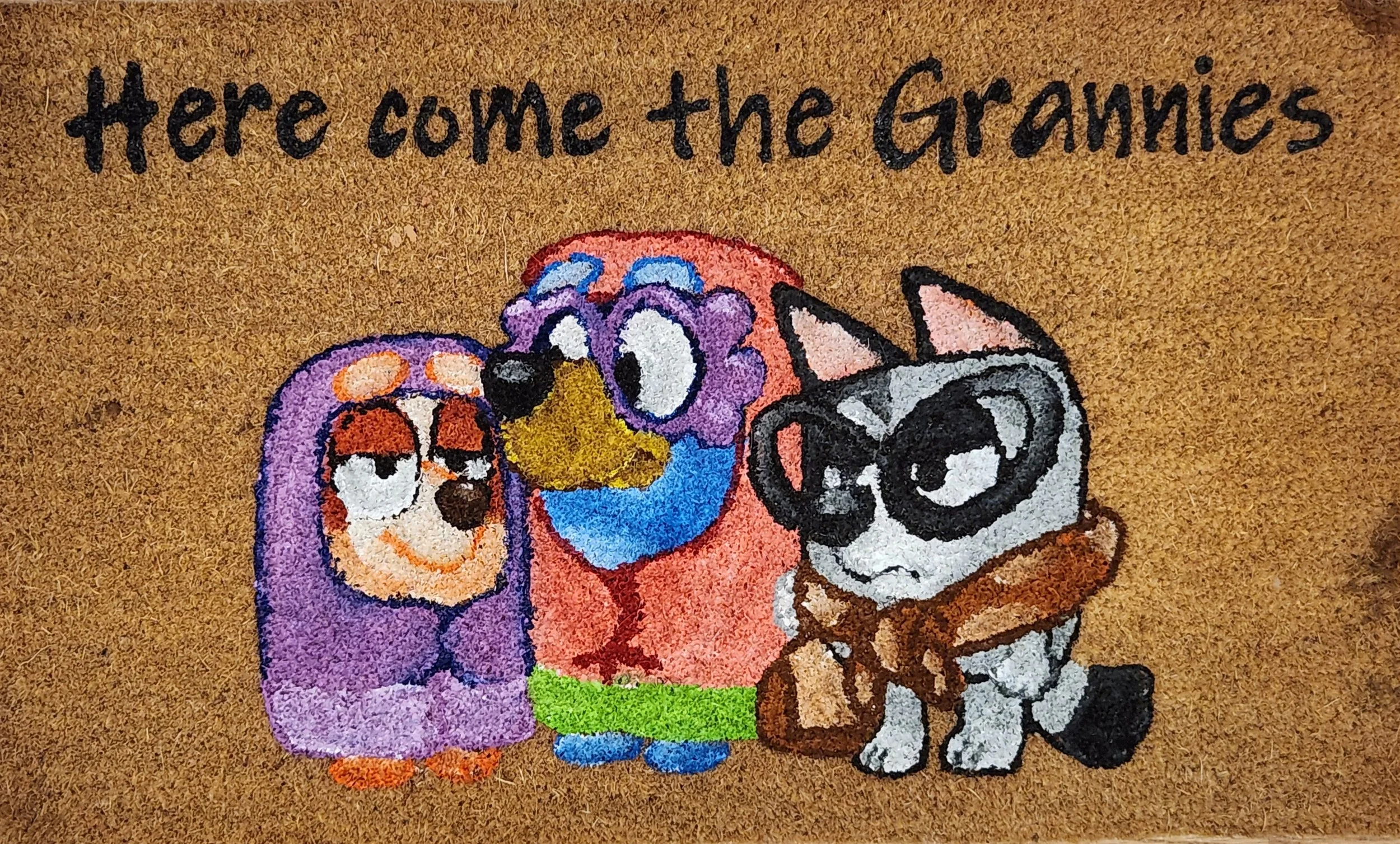 Drawing of three cartoon animals, including a purple owl, a multicolored bird, and a gray dog with glasses, with the text 'Here come the Grammies' above them.