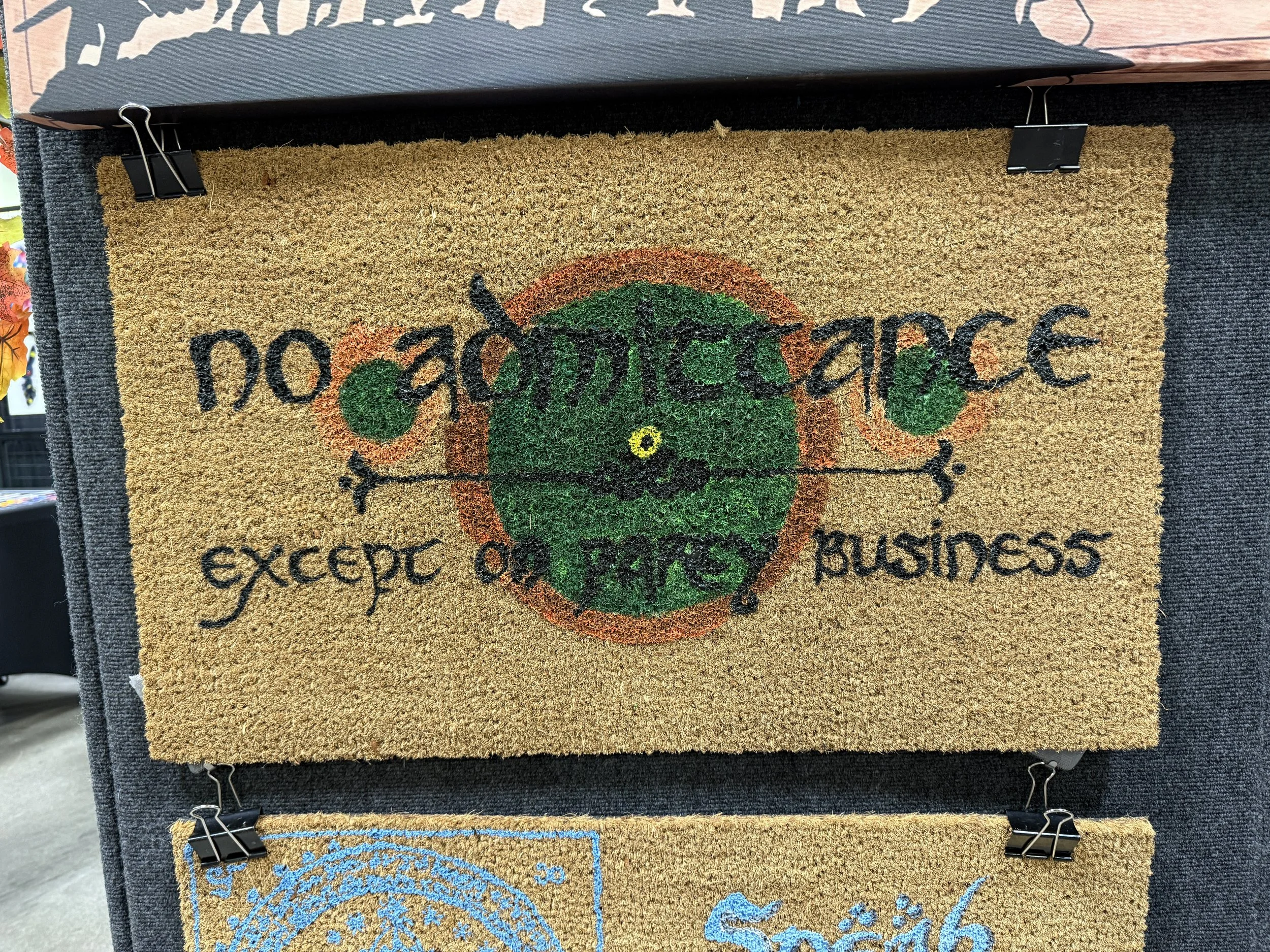 A doormat with the phrase 'no adversity except on your business' and a globe with a compass pointing in four directions.