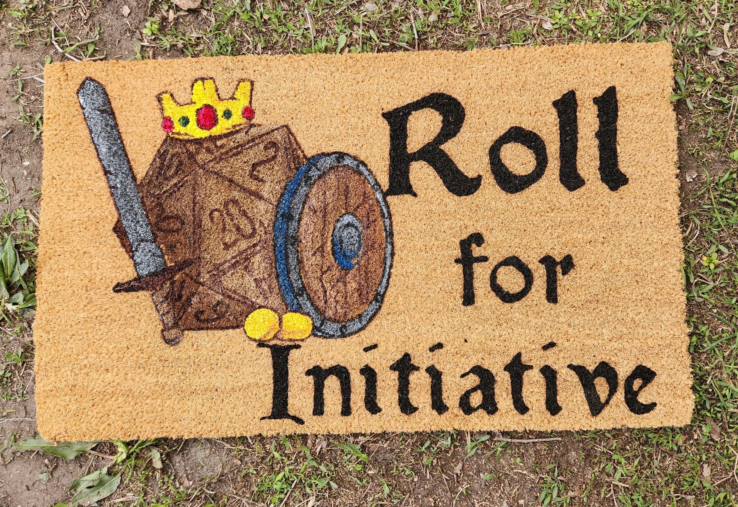 Doormat with a drawing of a dice, sword, shield, and yellow balls, along with the text 'Roll for Initiative' in black letters.