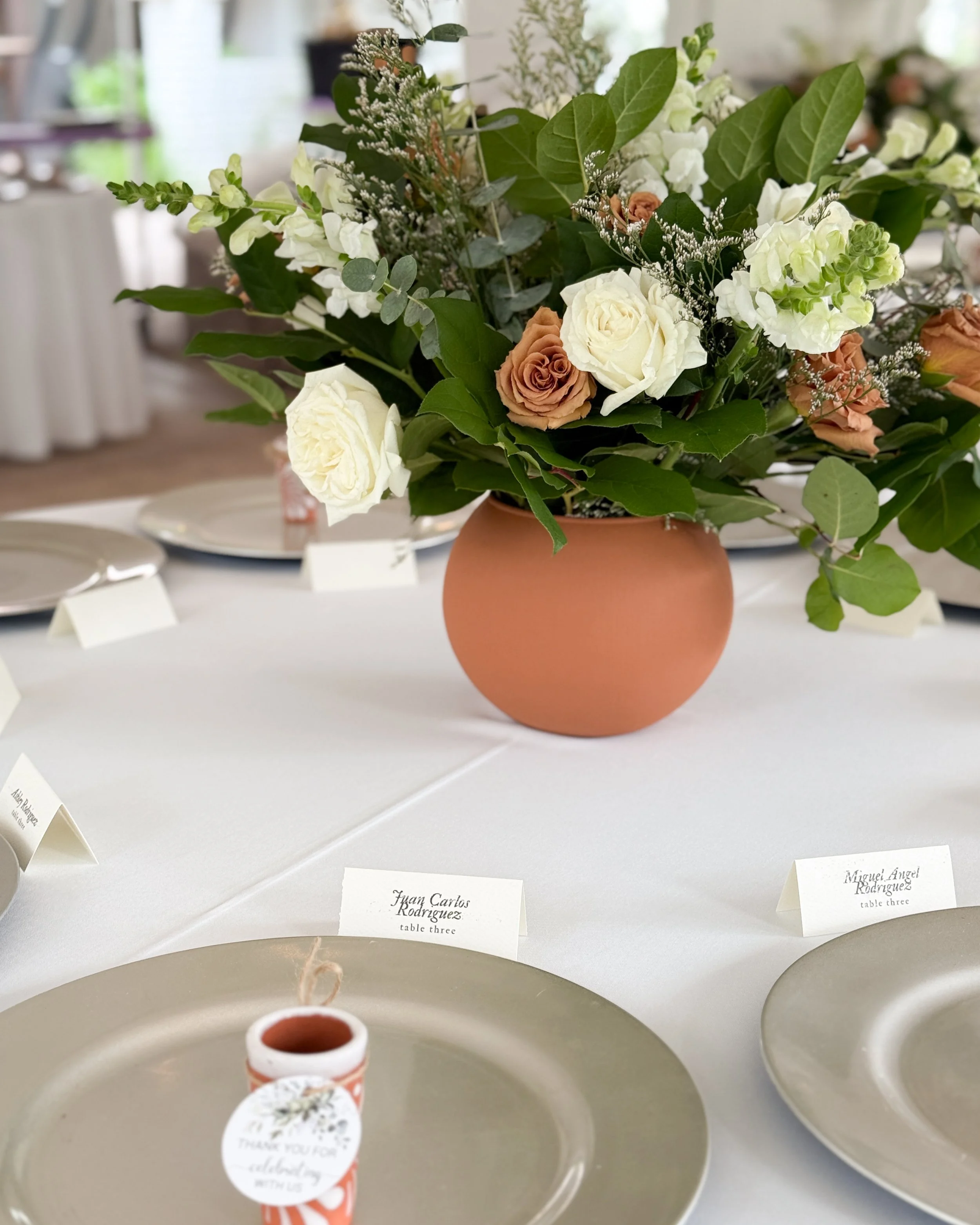 Wedding centerpiece with terracotta vase with white playa blanca roses and toffee roses