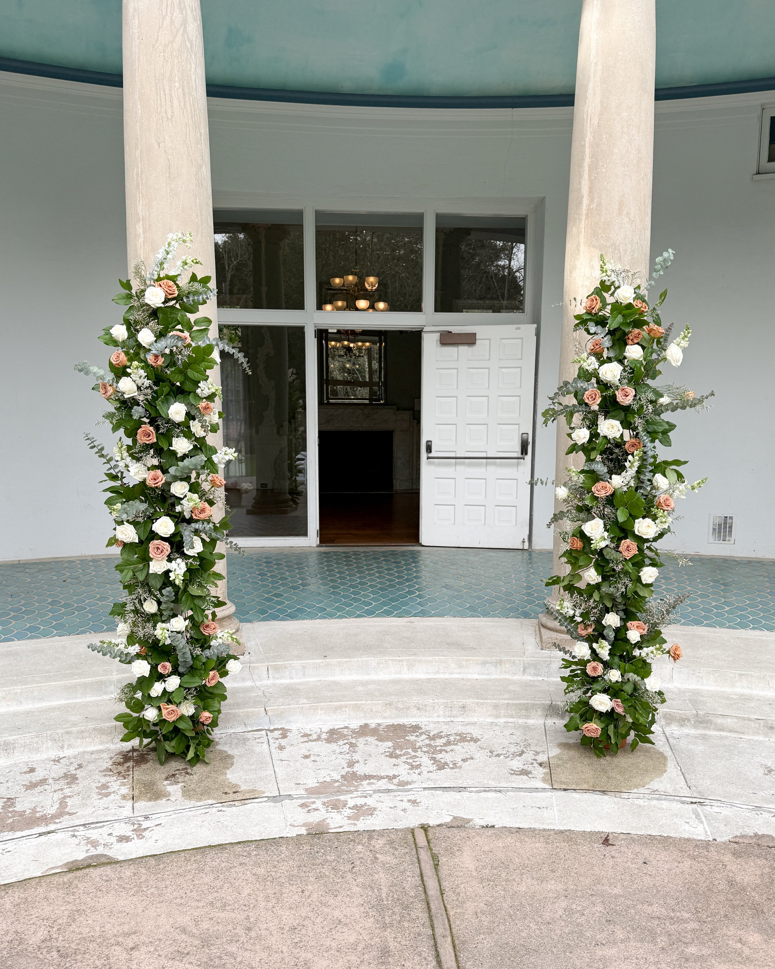 Wedding ceremony flower columns with white playa blanca roses and toffee roses